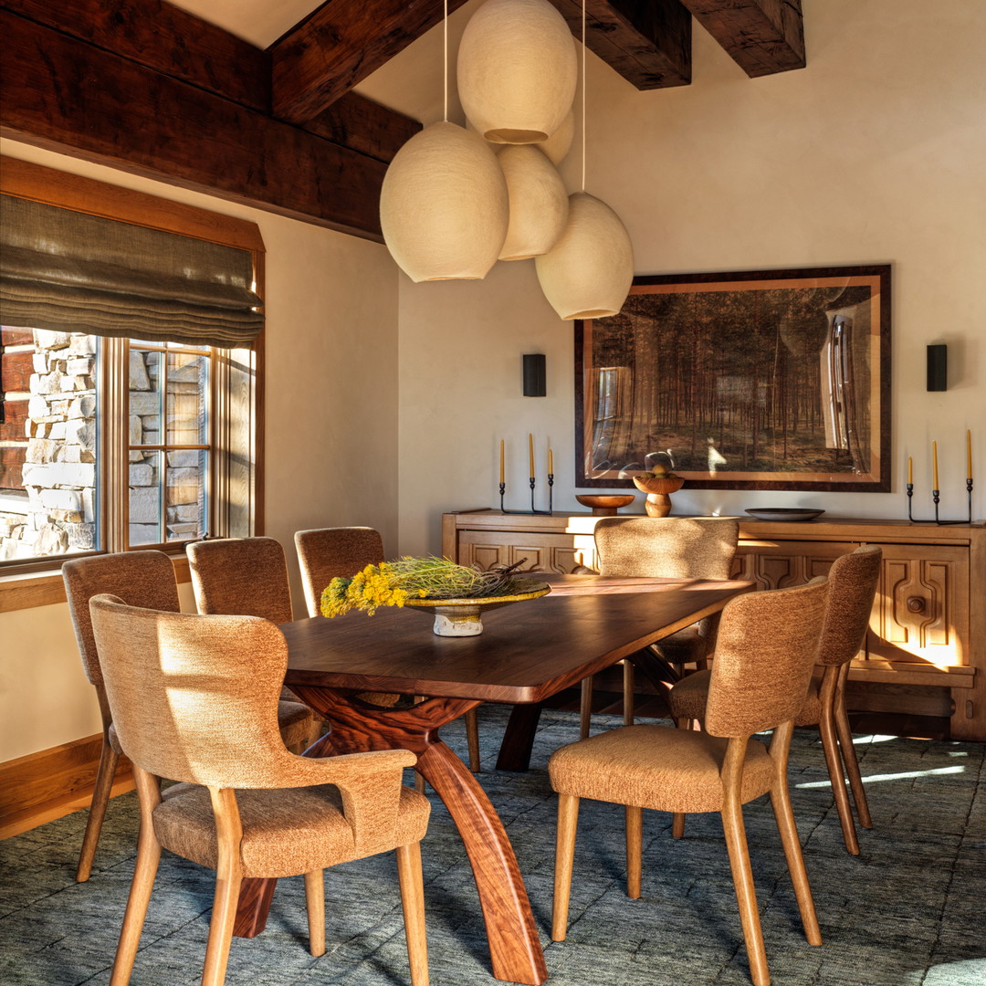 a dining room with a wooden table surrounded by chairs