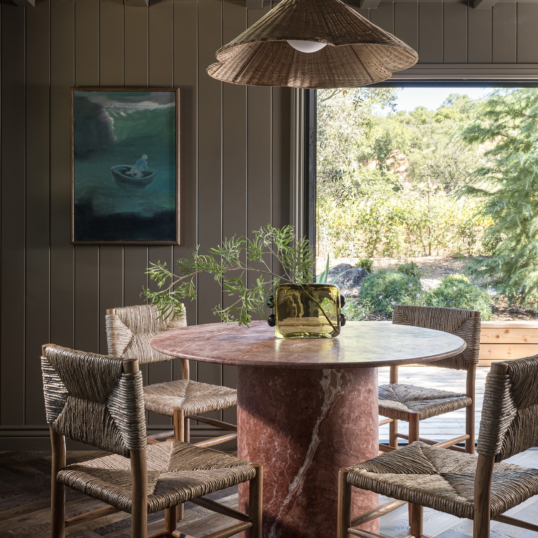 a dining room with a round table surrounded by chairs