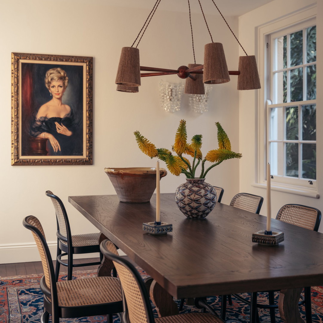 a dining room table with a vase of flowers on it