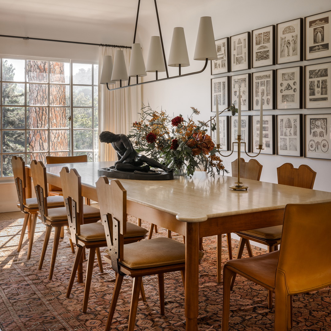 a dining room table with a vase of flowers on top of it