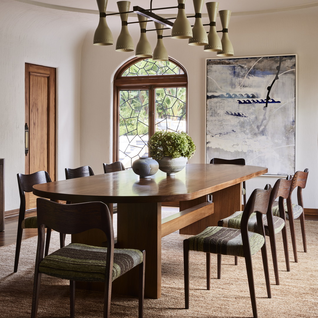 a dining room with a large wooden table surrounded by chairs