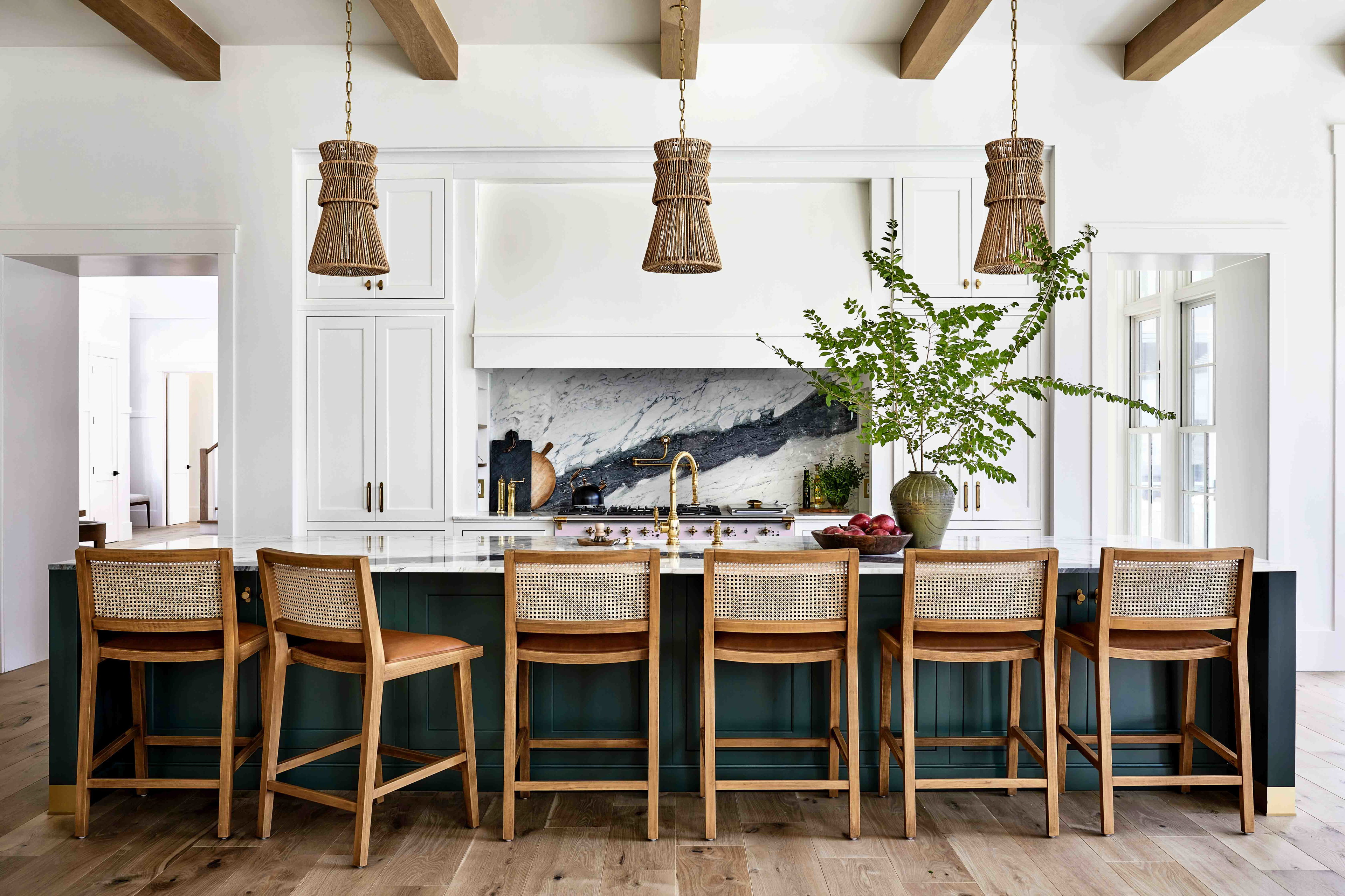 a kitchen with a center island surrounded by wooden chairs