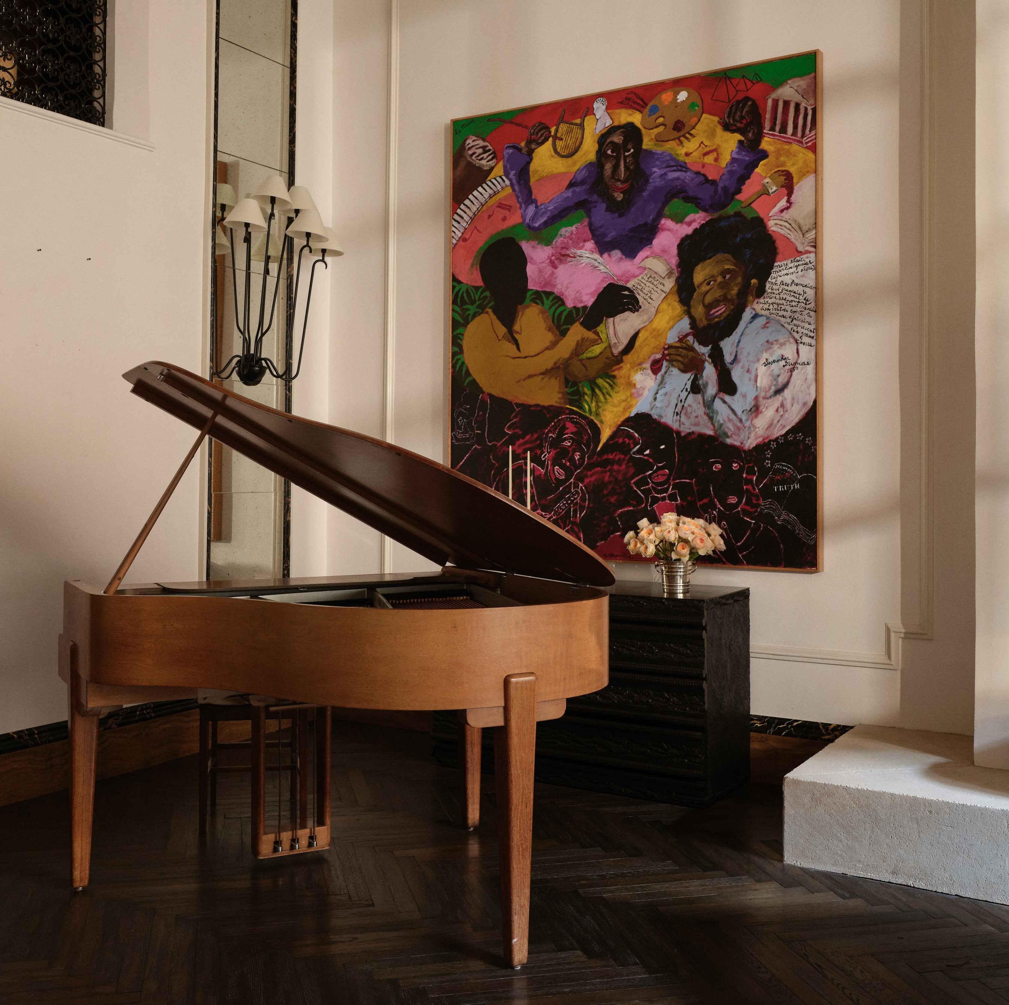 a grand piano in a room with a painting on the wall