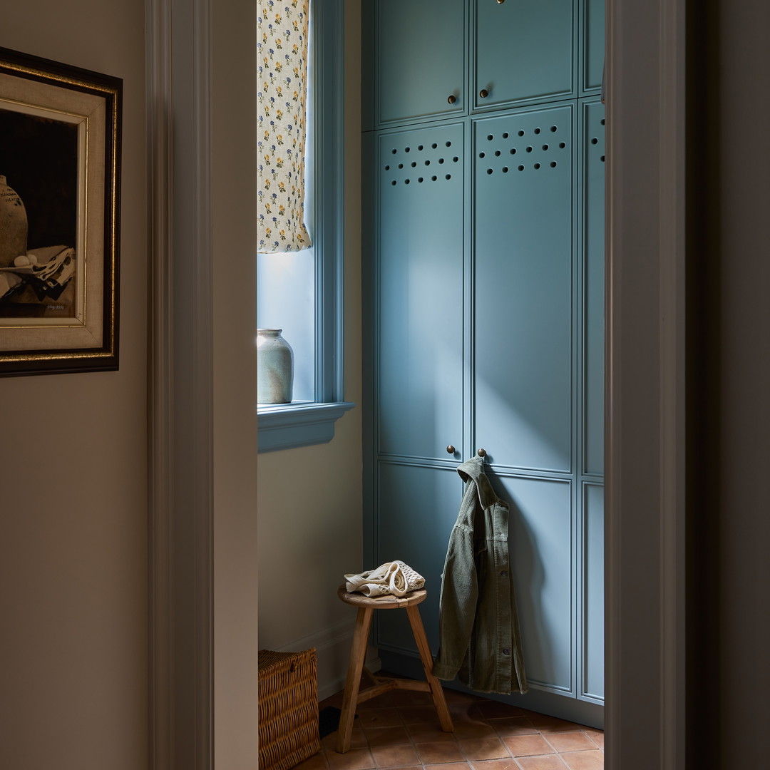 a blue locker in a hallway with a coat rack