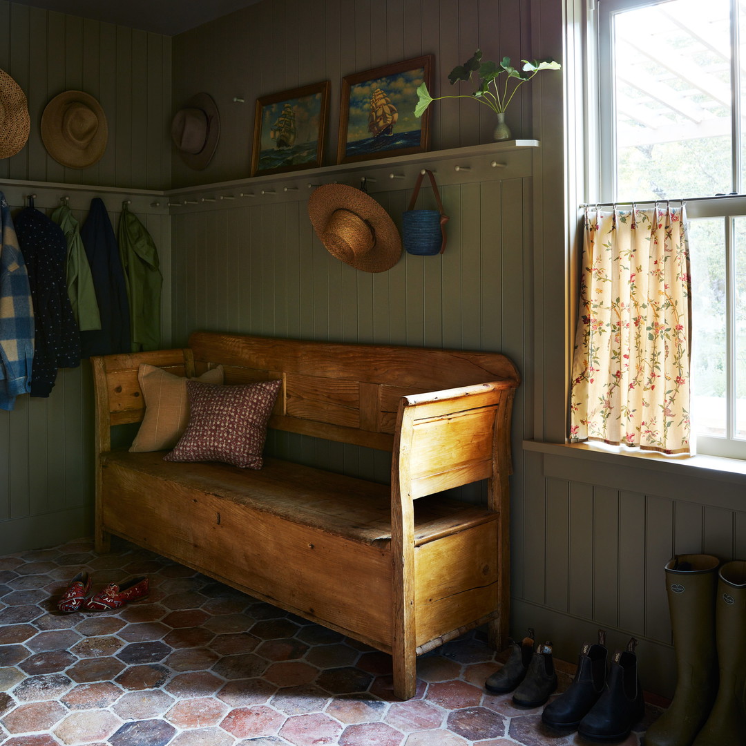 a wooden bench sitting in a room next to a window