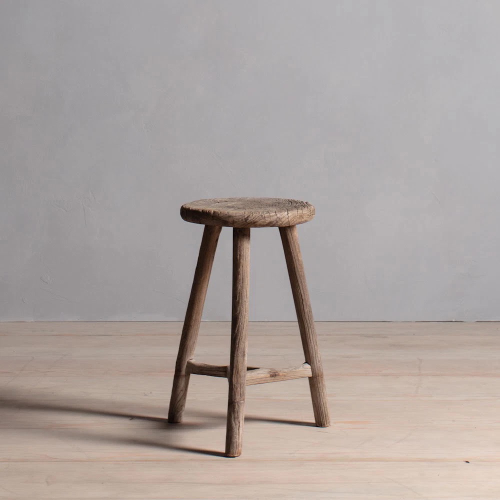 a wooden stool sitting on top of a hard wood floor