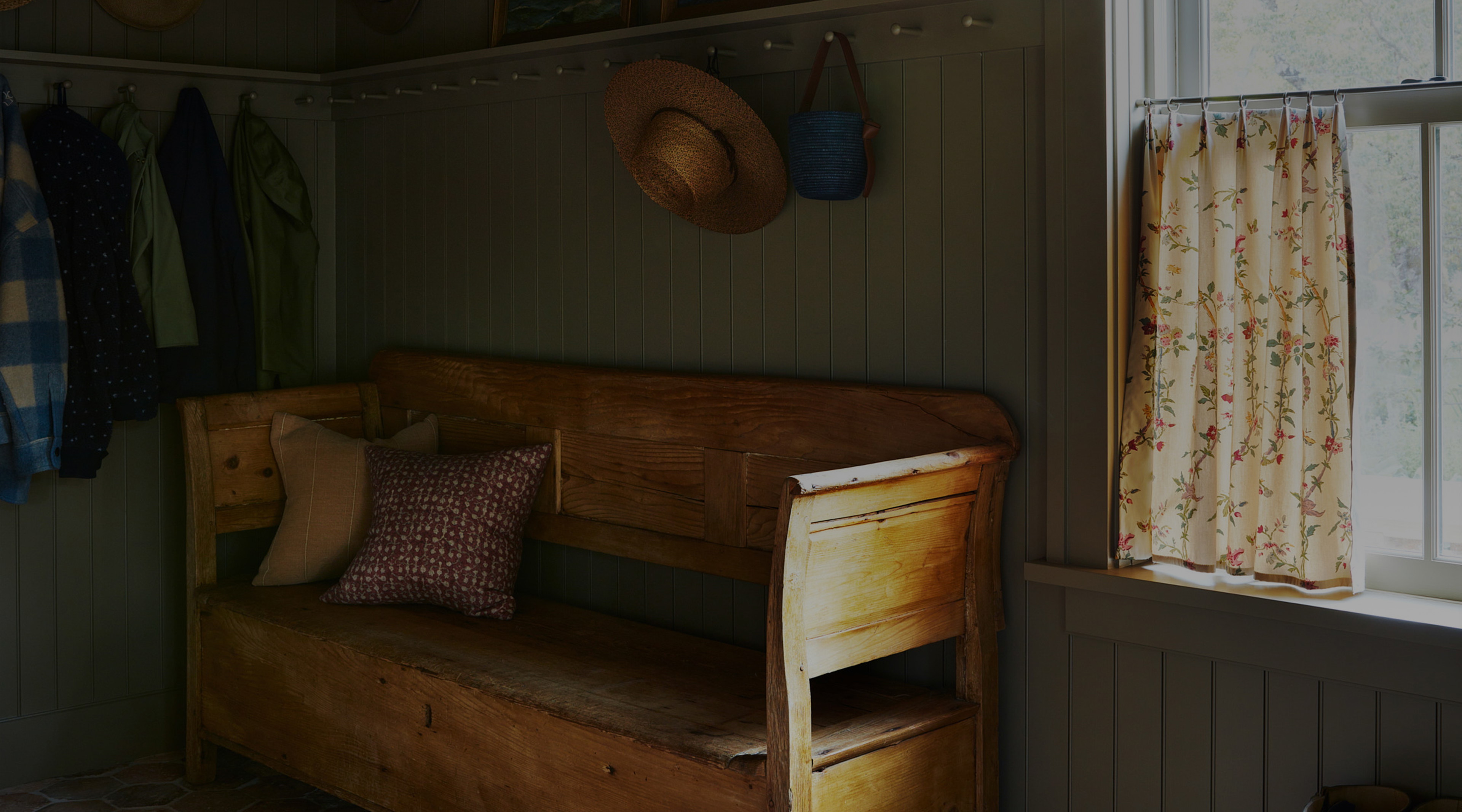 a wooden bench sitting in a room next to a window