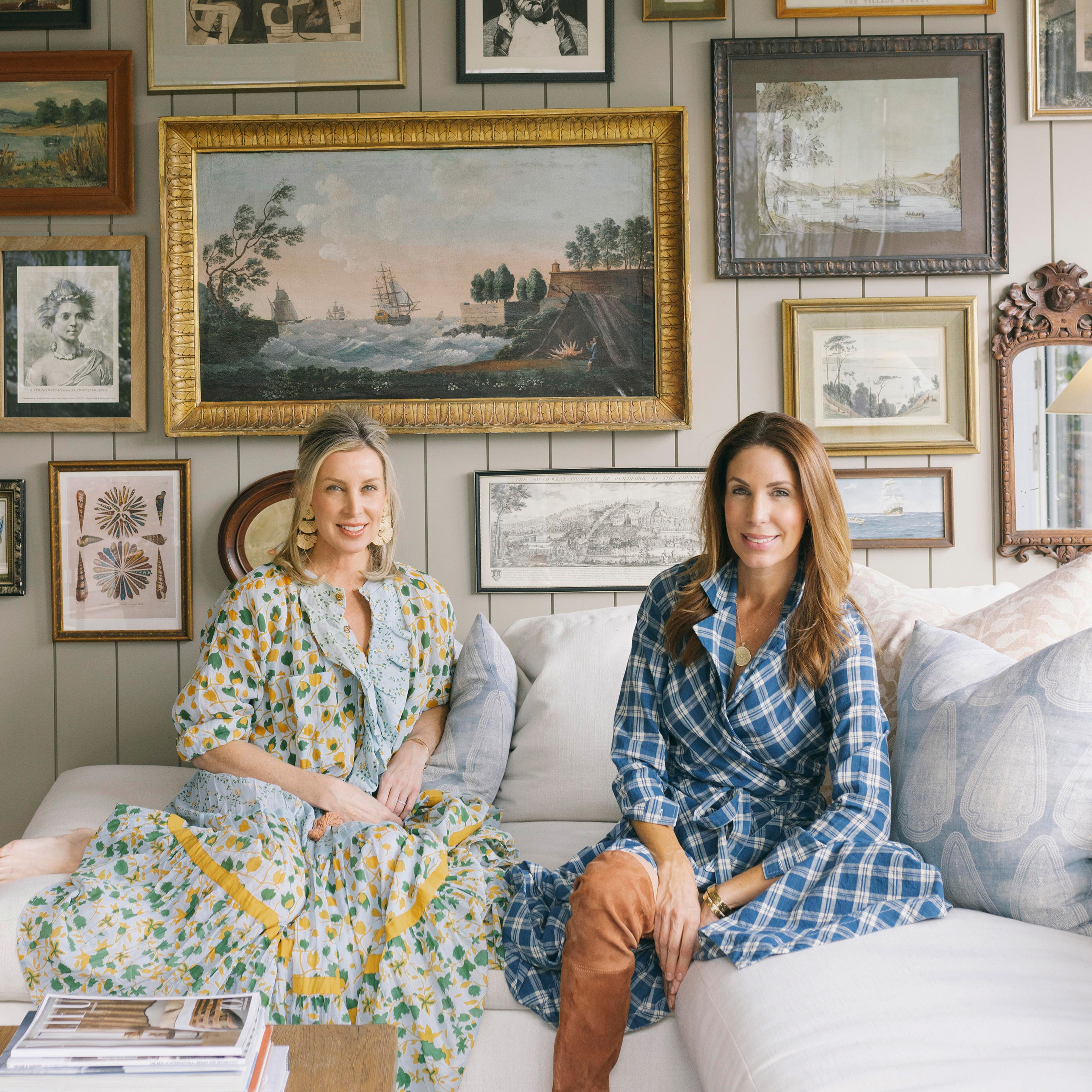 a couple of women sitting on top of a white couch