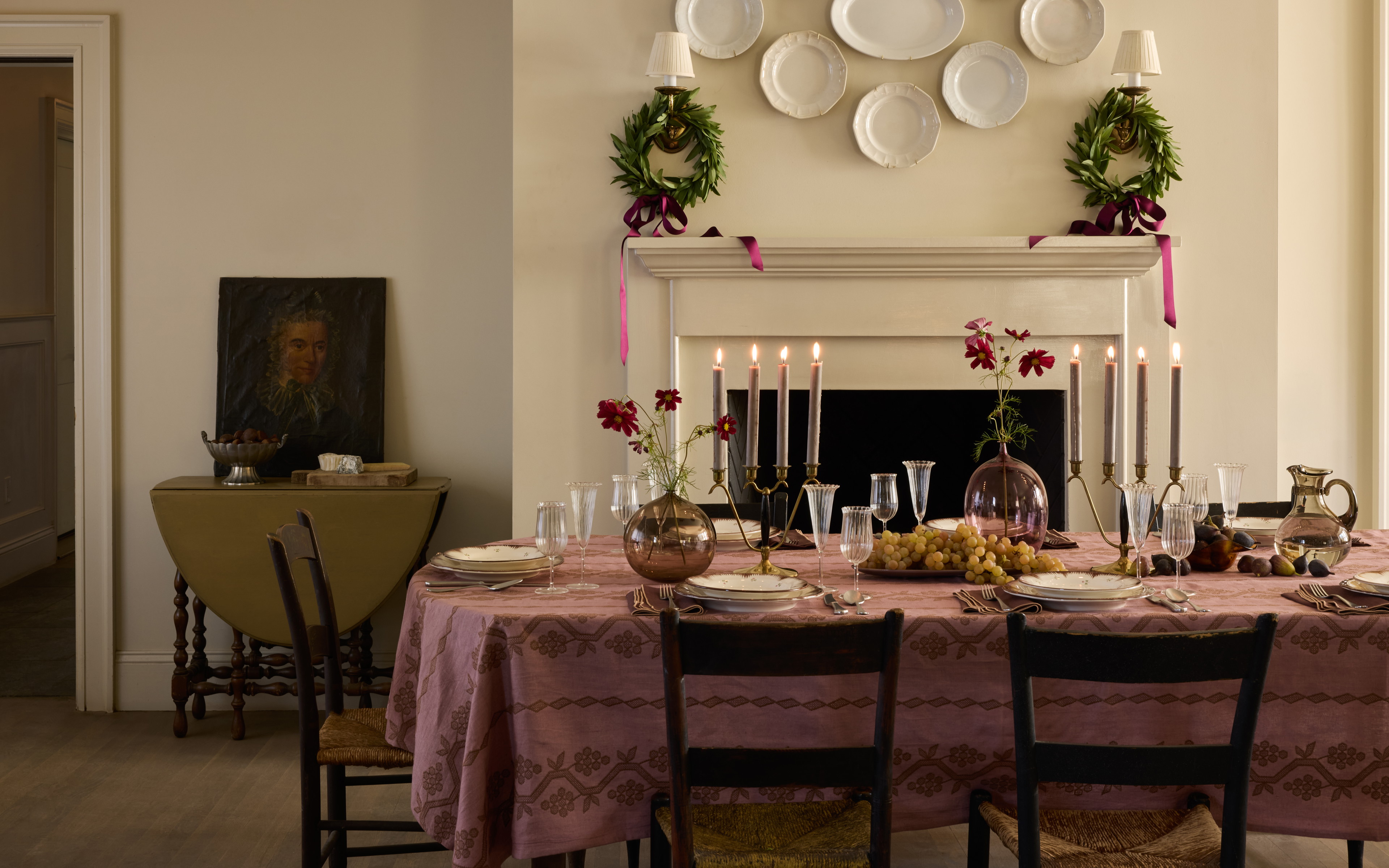 a dining room table set with plates and candles