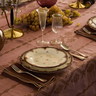 a table set with plates, silverware and wine glasses