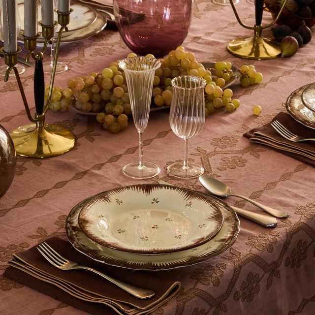 a table set with plates, silverware and wine glasses