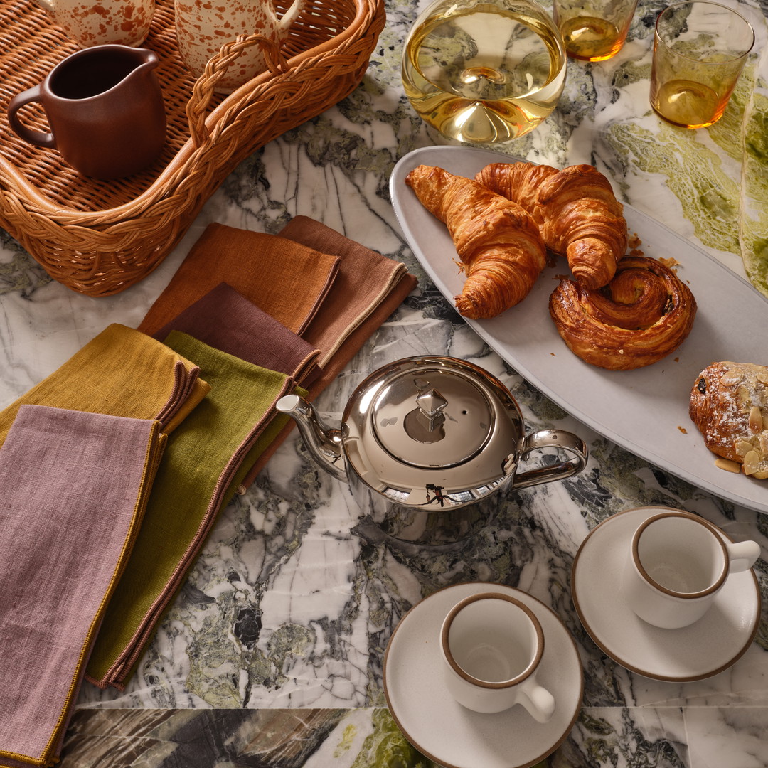 a table topped with plates of food and cups