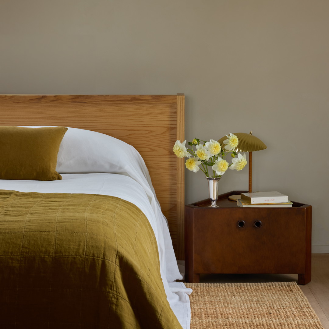 a bedroom with a bed, nightstand, and flowers