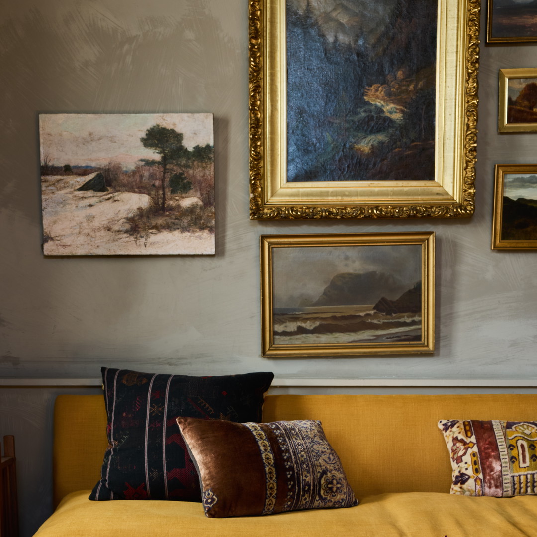 a living room filled with furniture and a painting on the wall