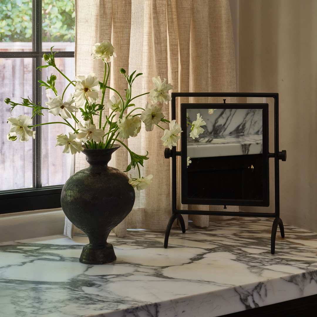 a vase of flowers sitting on a table next to a window