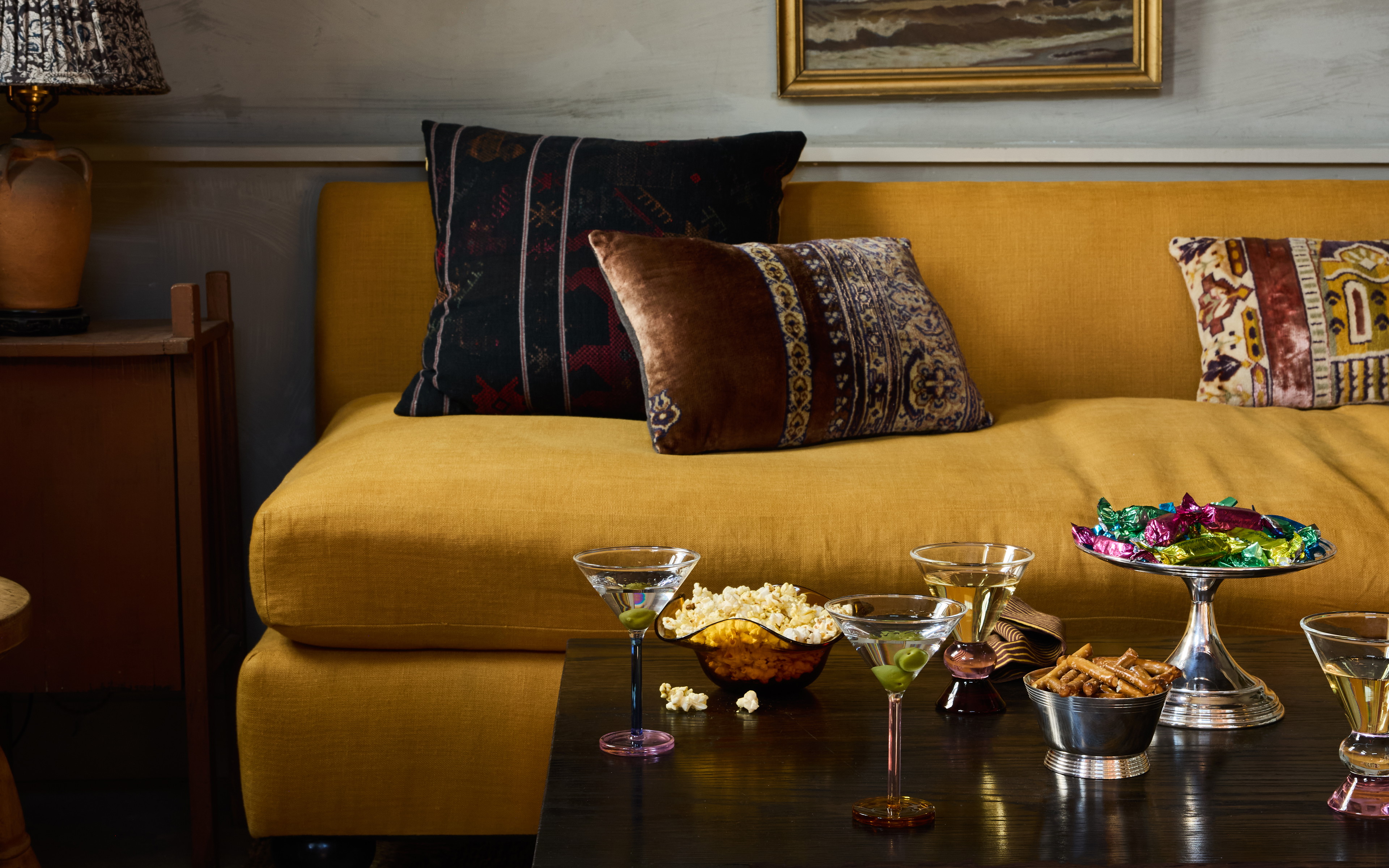 a living room filled with furniture and a painting on the wall