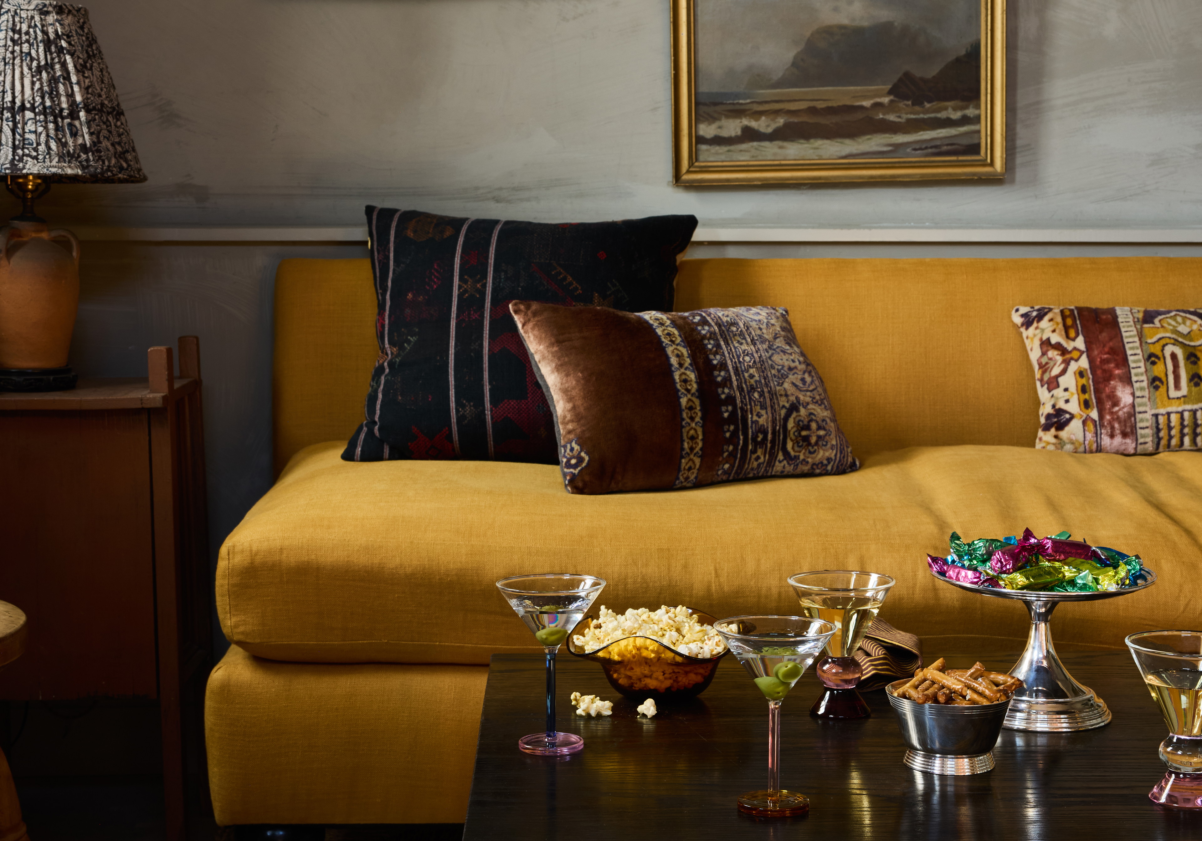 a living room filled with furniture and a painting on the wall