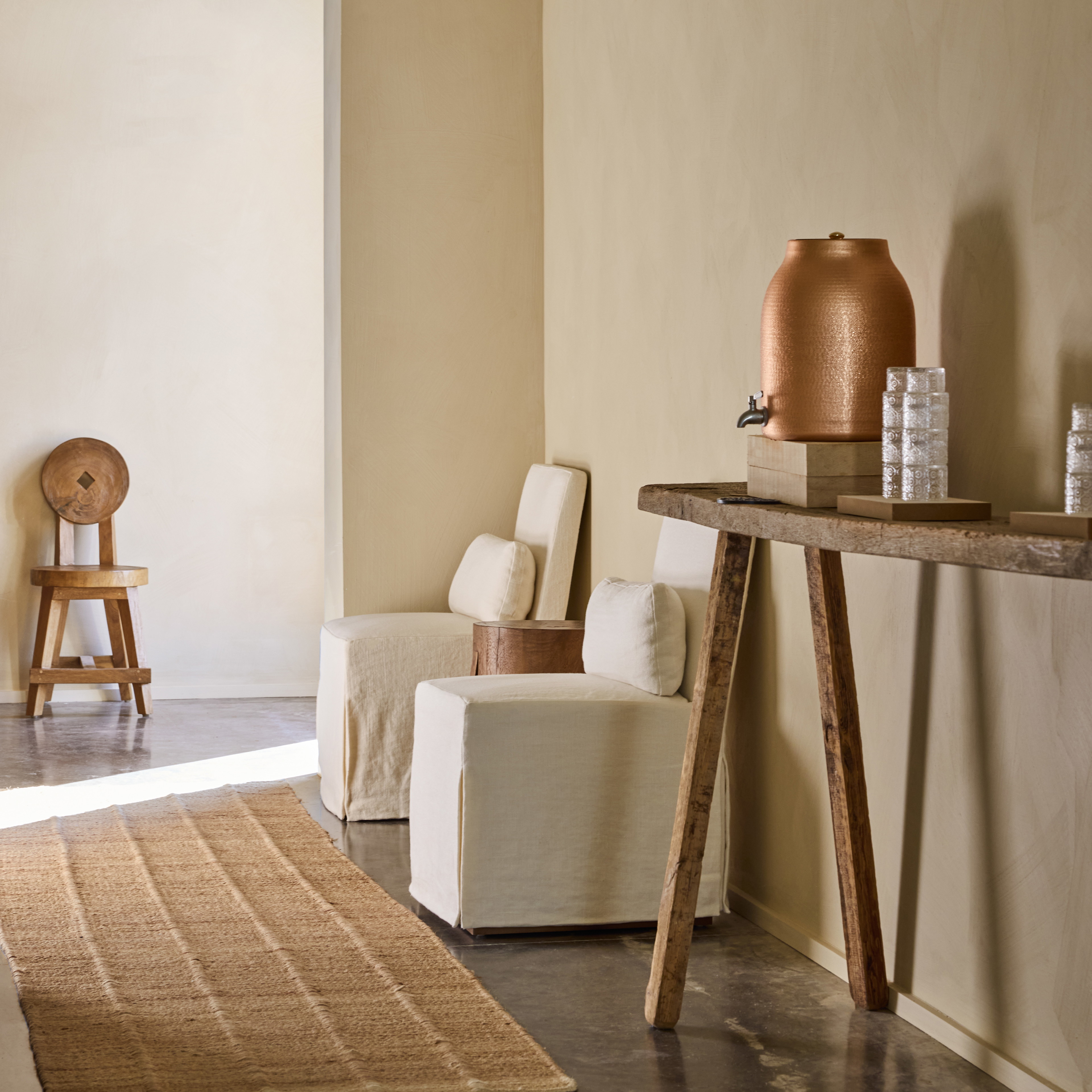 a living room with a table a chair and a vase