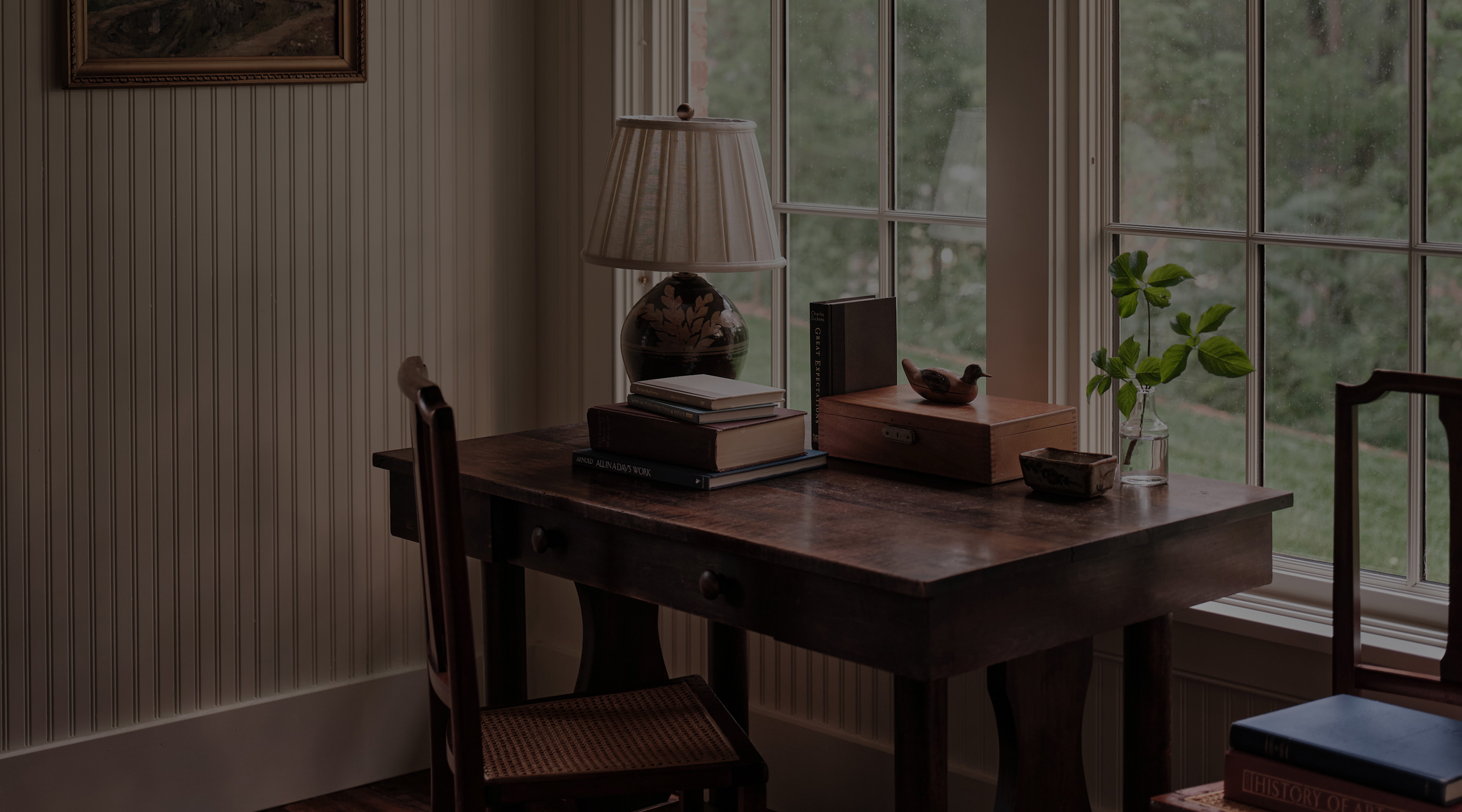 a desk with a lamp, books and a teddy bear on it