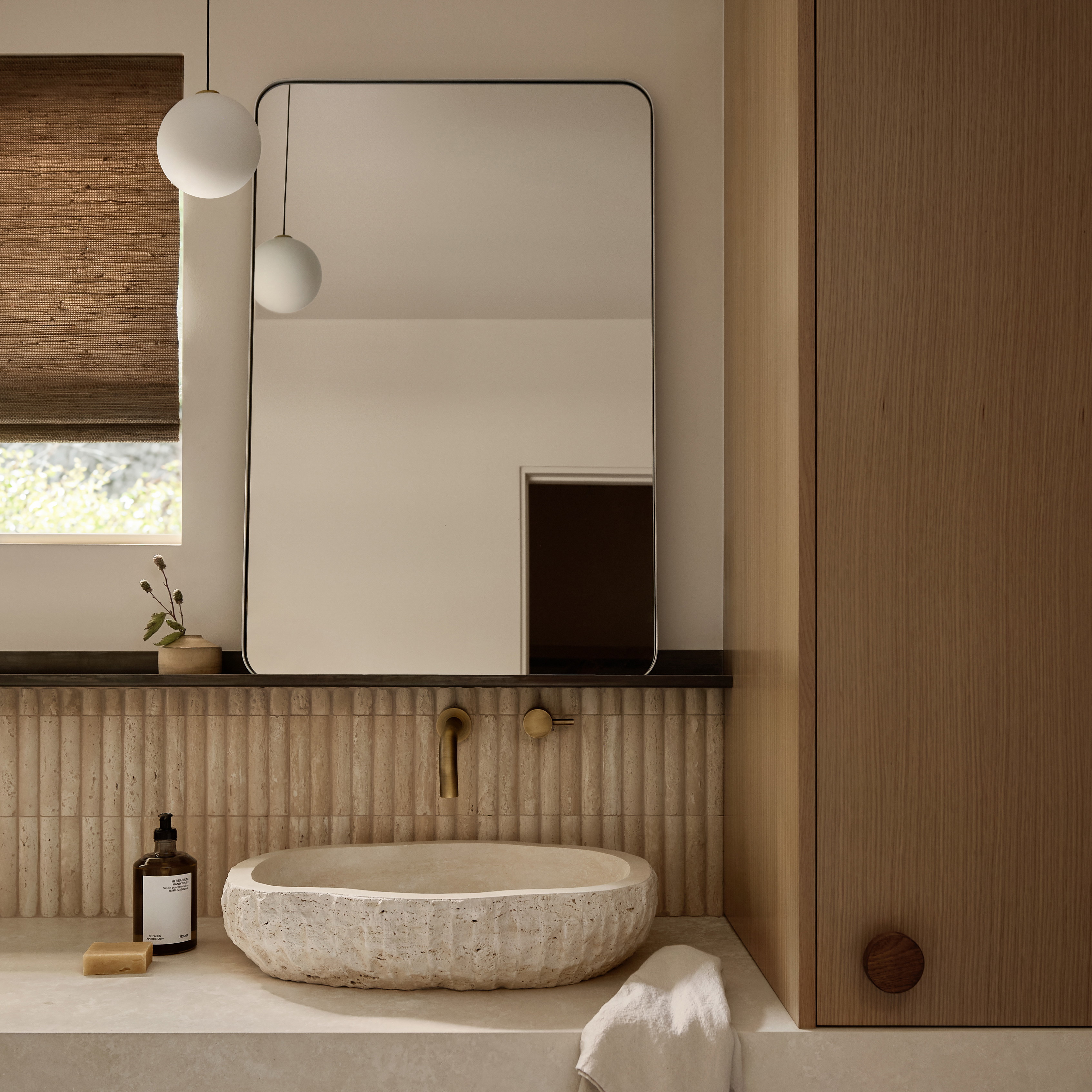 a white sink sitting under a bathroom mirror