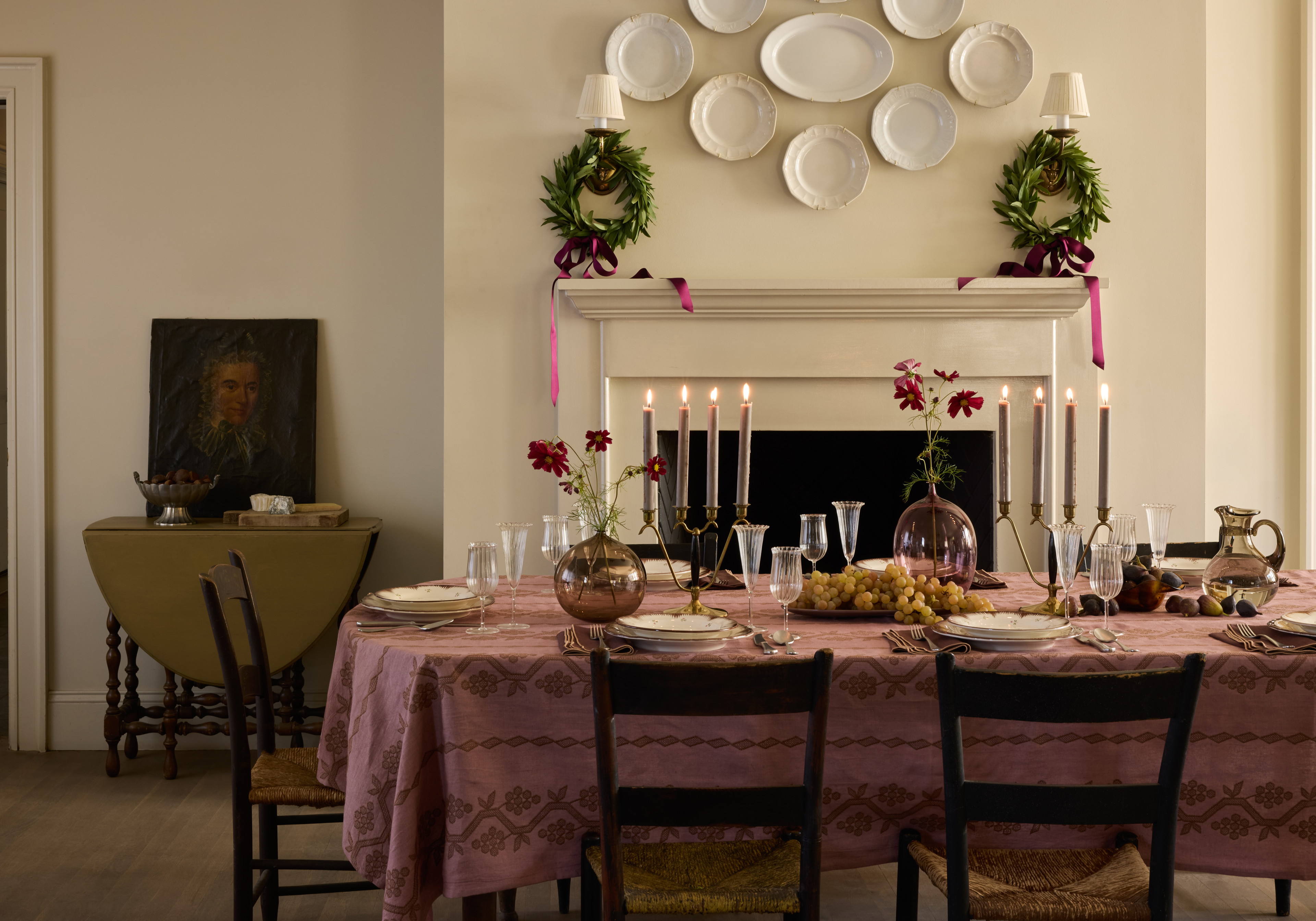 a dining room table set with plates and candles