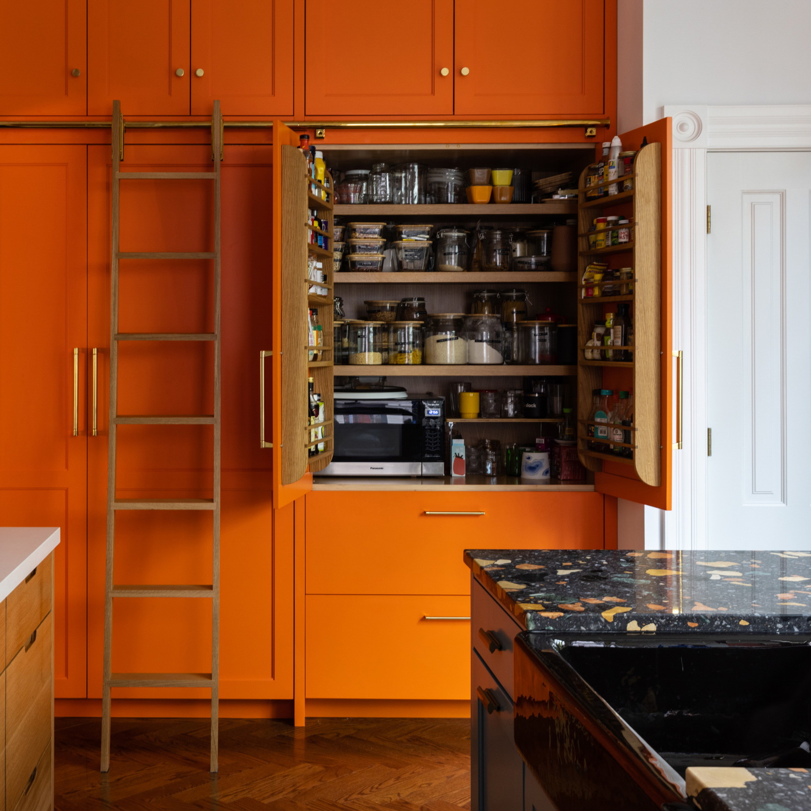 a kitchen with orange cabinets and a ladder