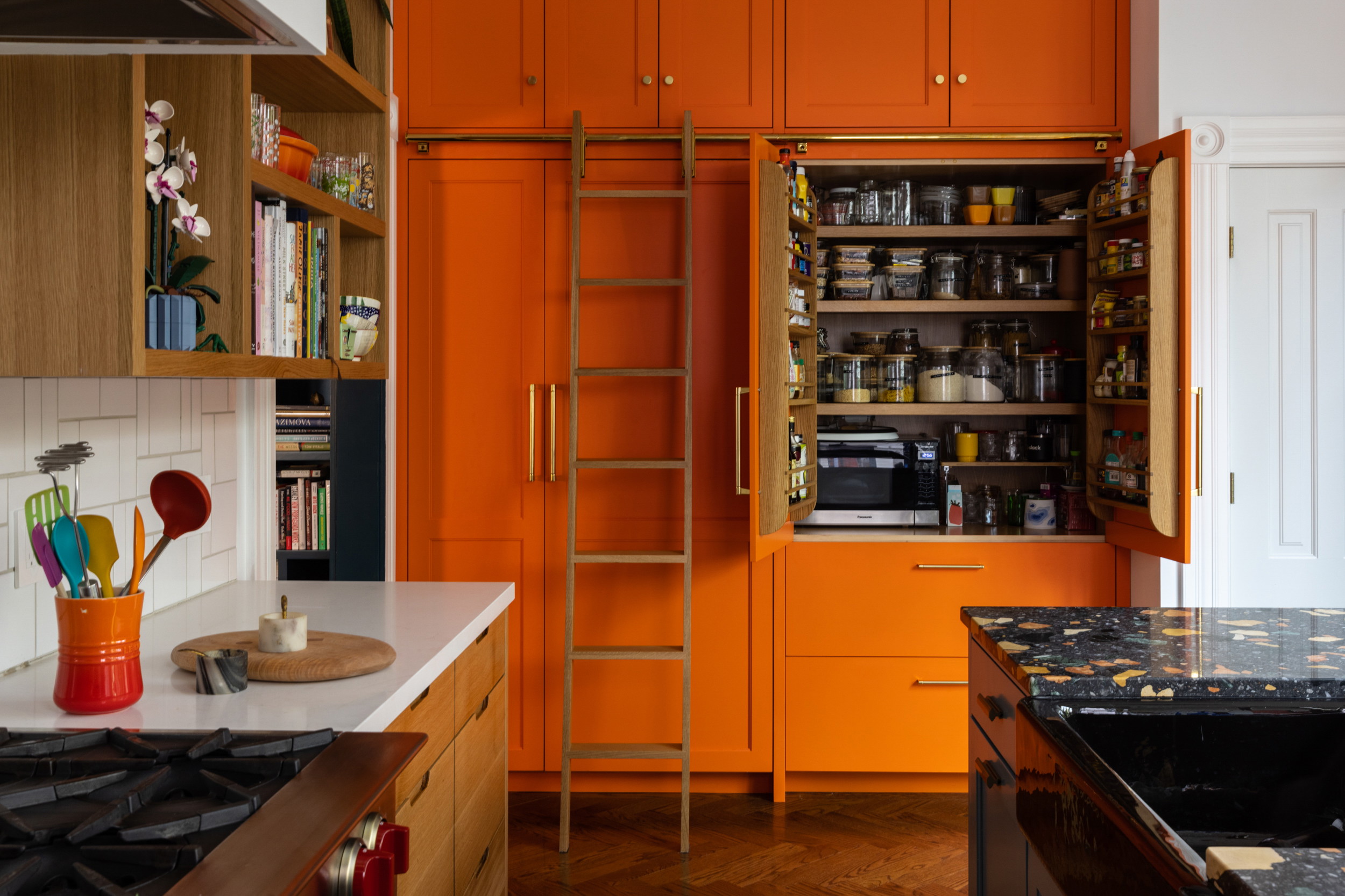 a kitchen with orange cabinets and a ladder