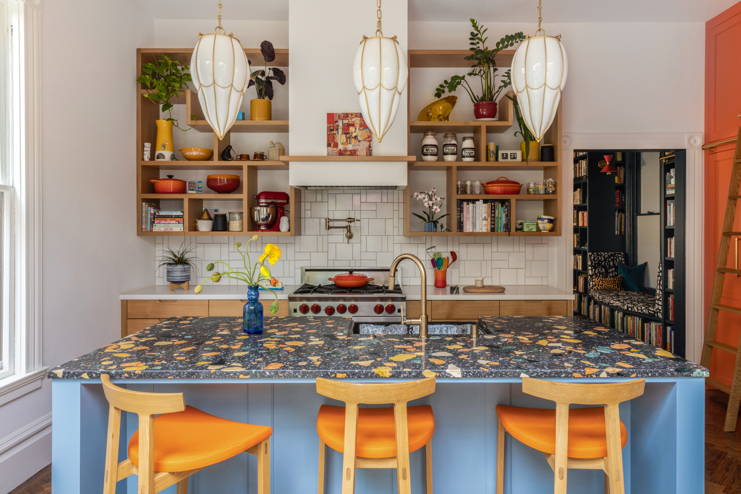 a kitchen with a blue island and yellow stools