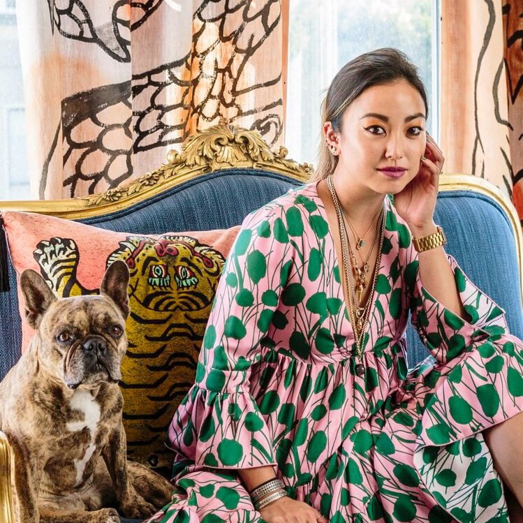 a woman sitting on a couch next to a dog