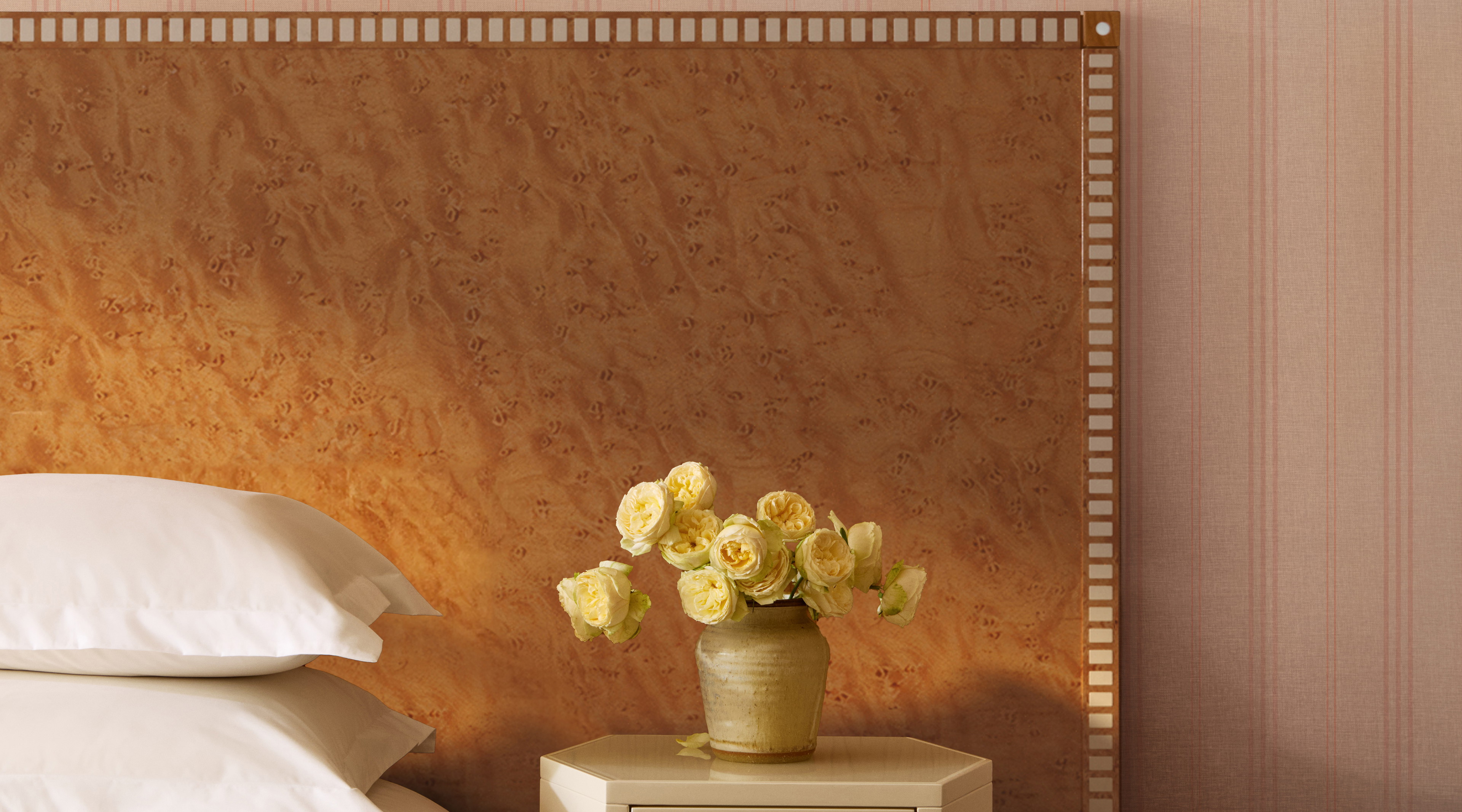 a vase of flowers sitting on a nightstand next to a bed