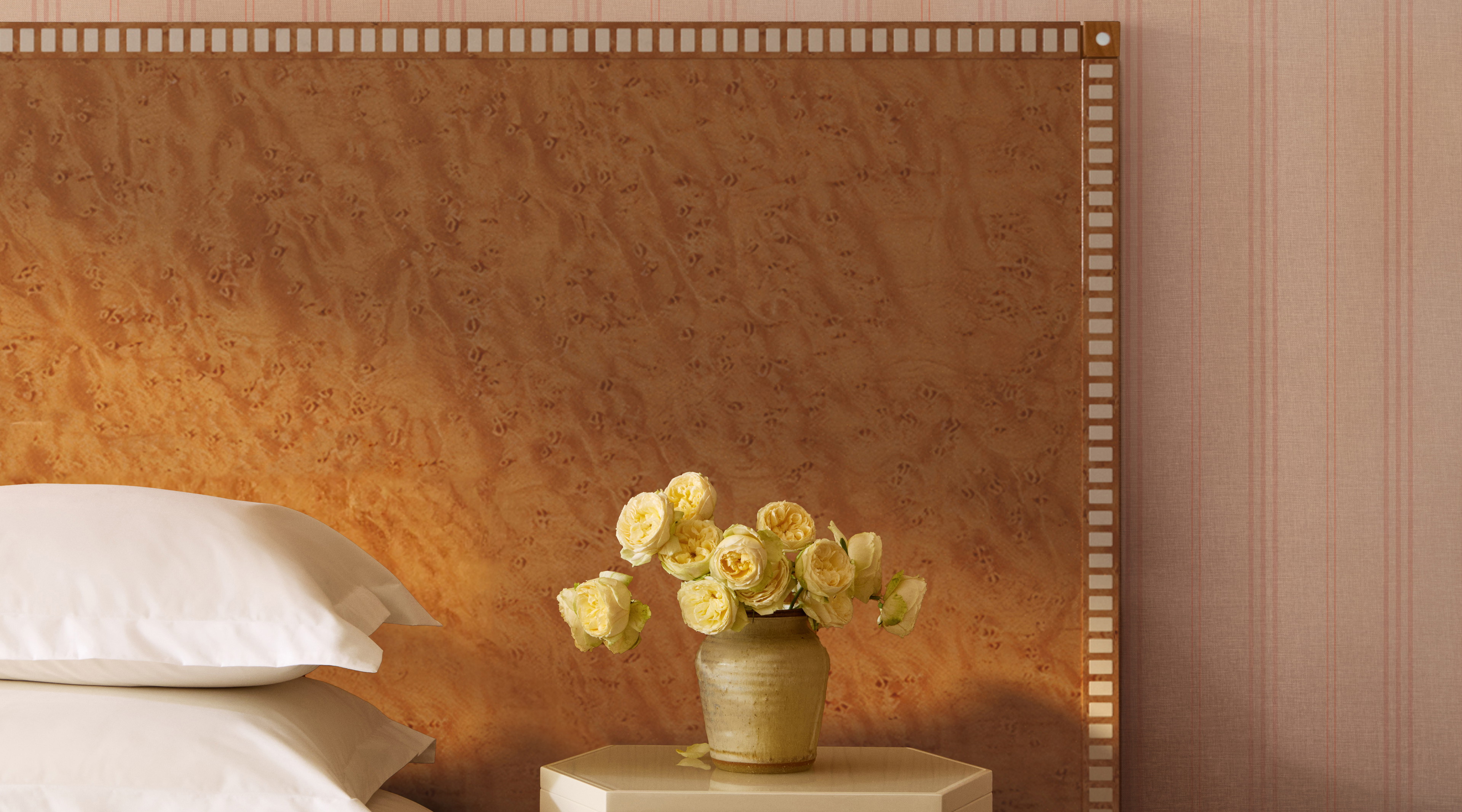 a vase of flowers sitting on a nightstand next to a bed