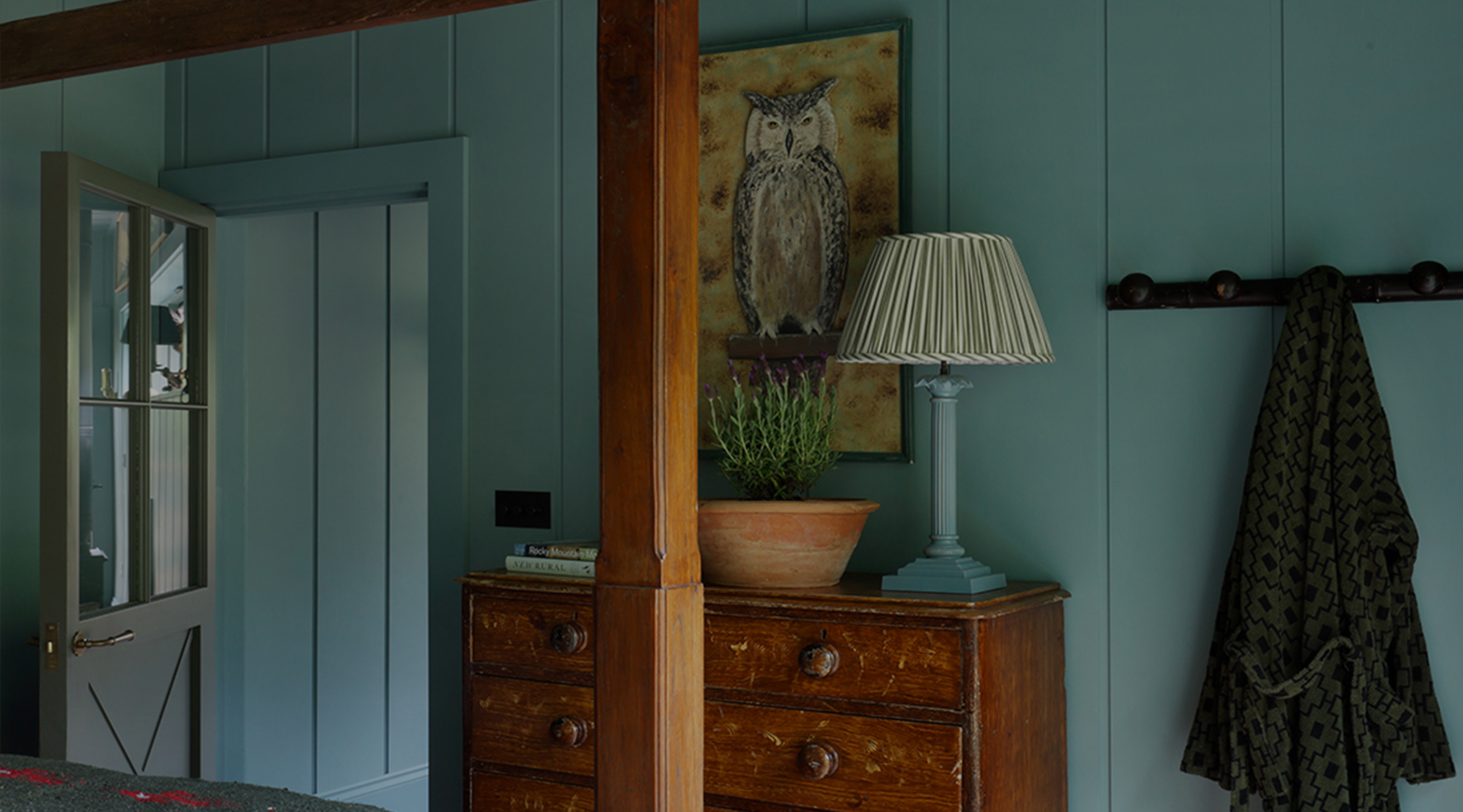 a bedroom with a bed, dresser and a painting on the wall