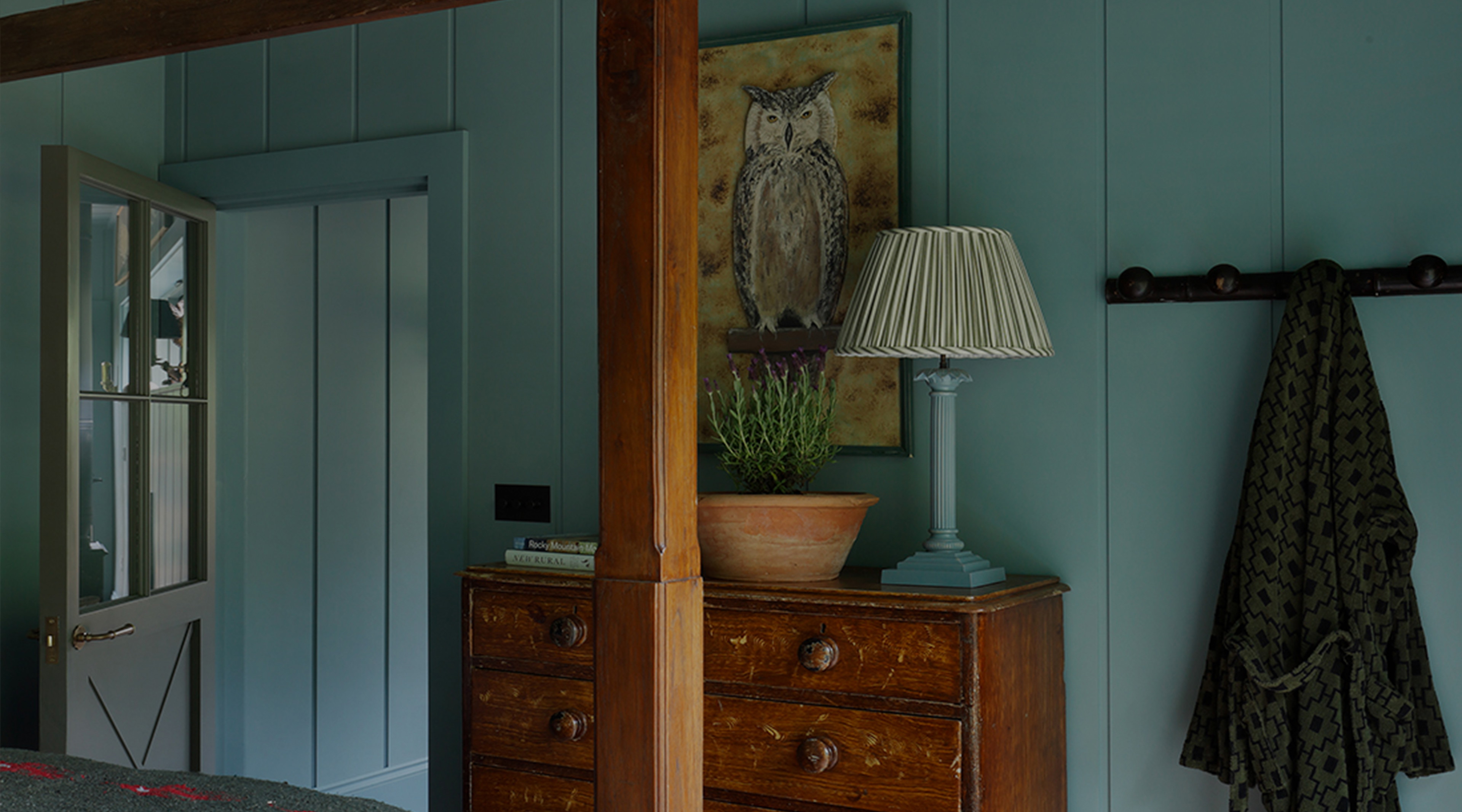 a bedroom with a bed, dresser and a painting on the wall