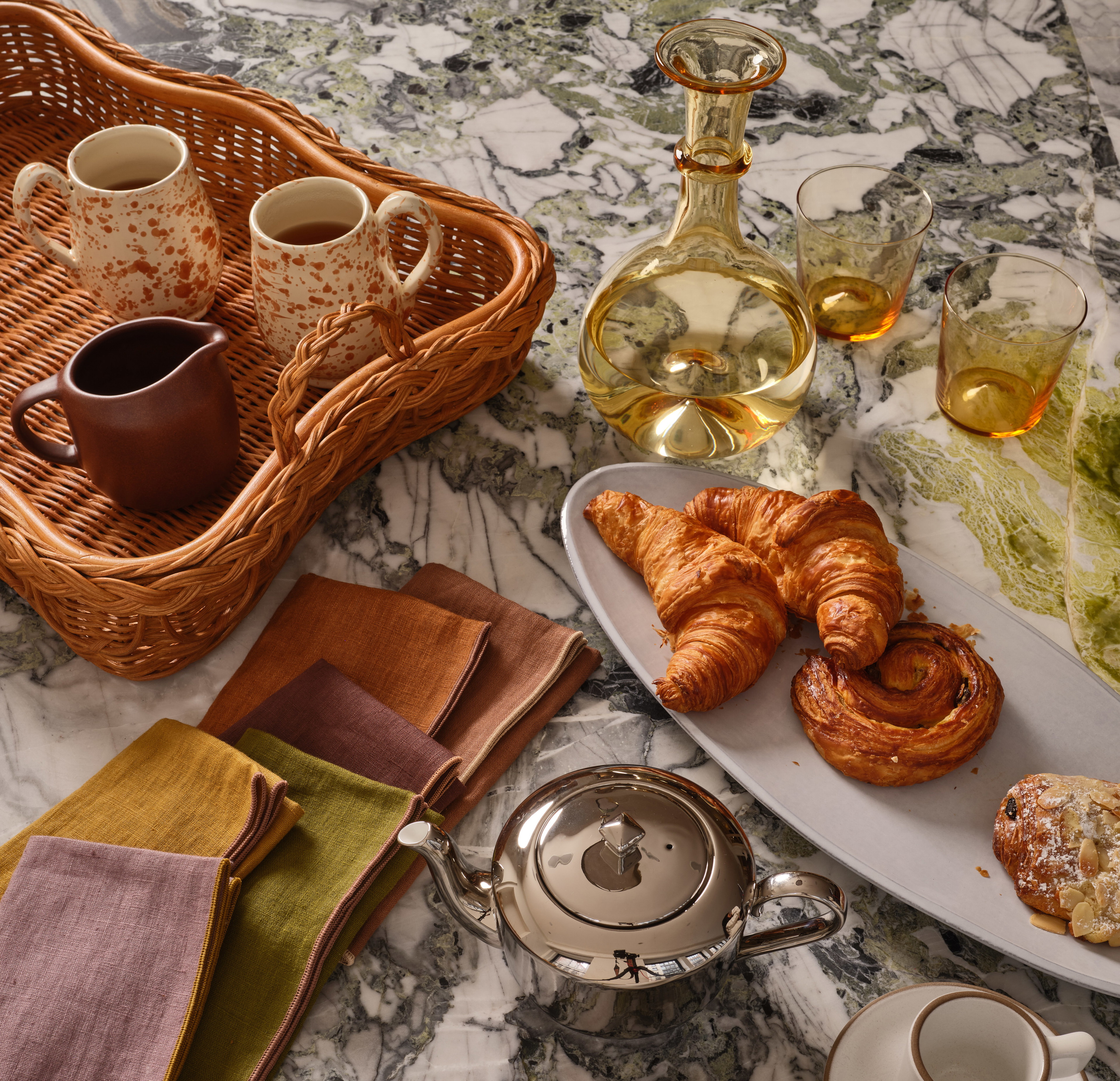 a table topped with plates of food and cups