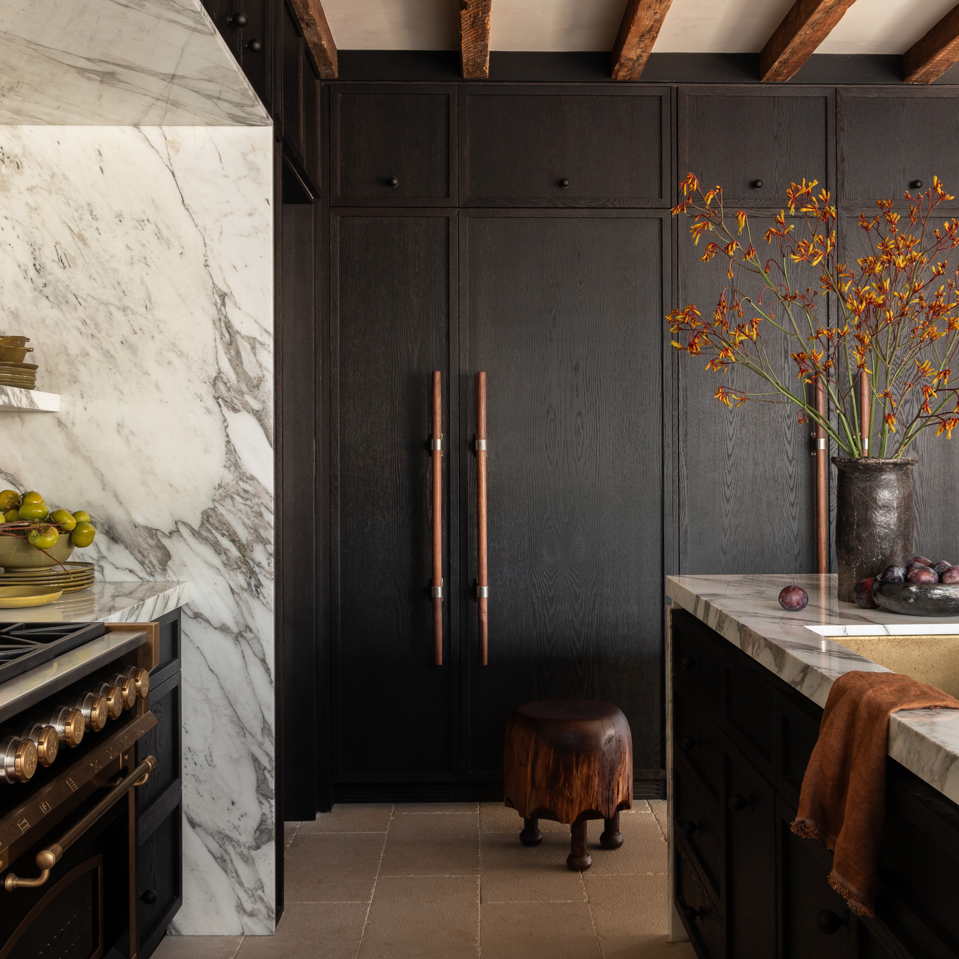 a kitchen with marble counter tops and black cabinets