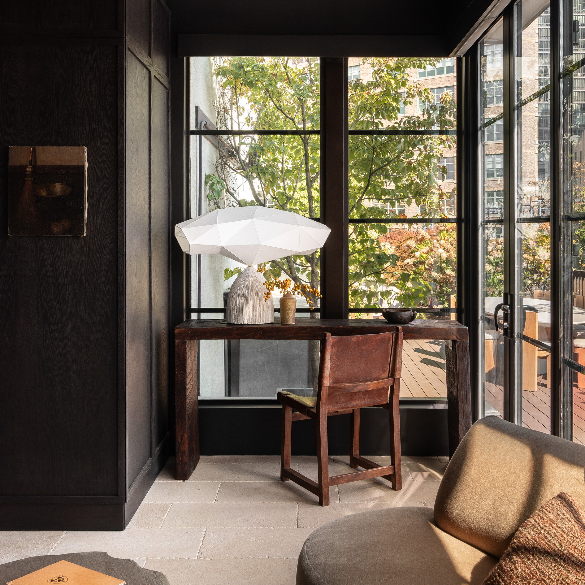 a room with a table, chair, lamp and window