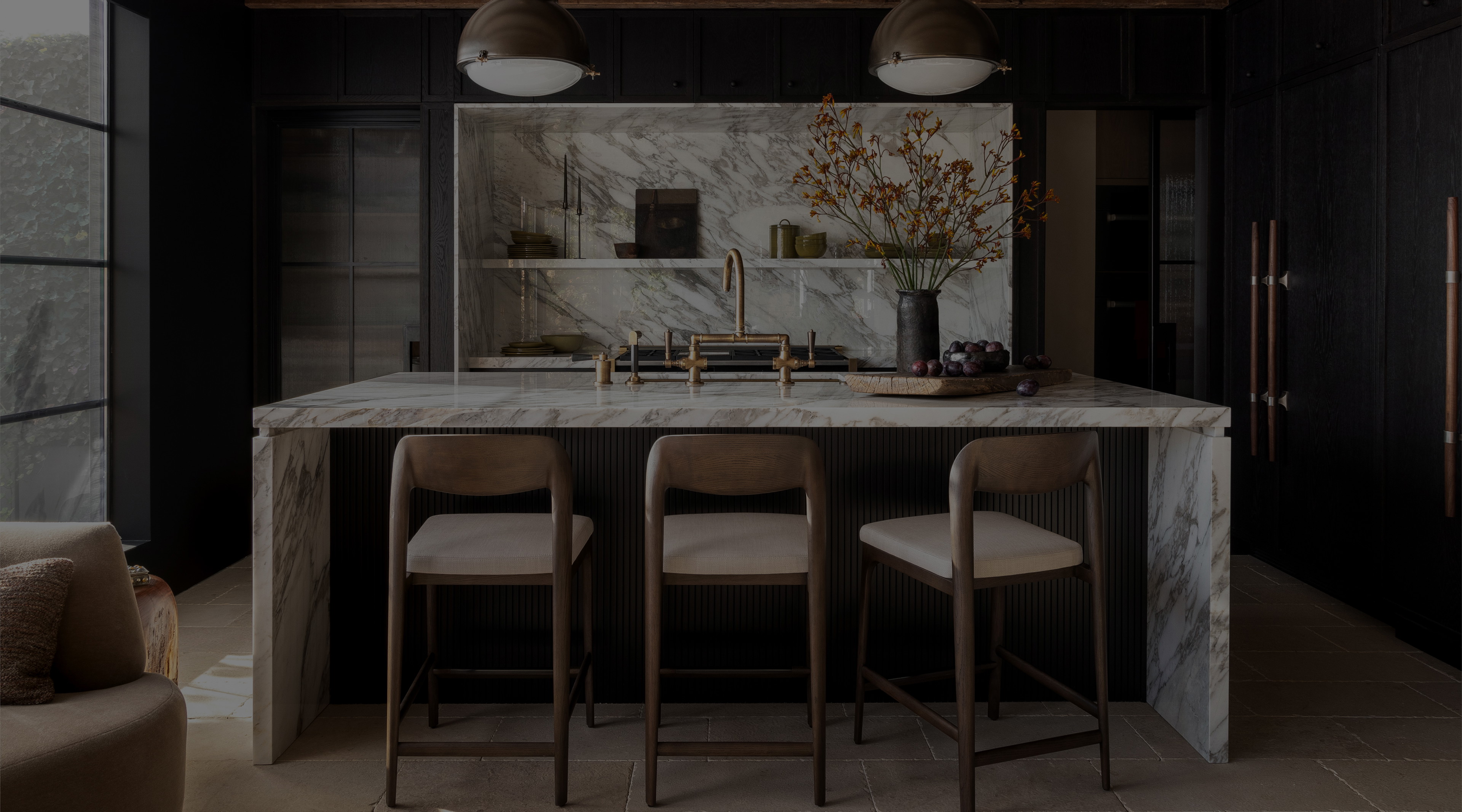 a kitchen with a marble counter top and bar stools