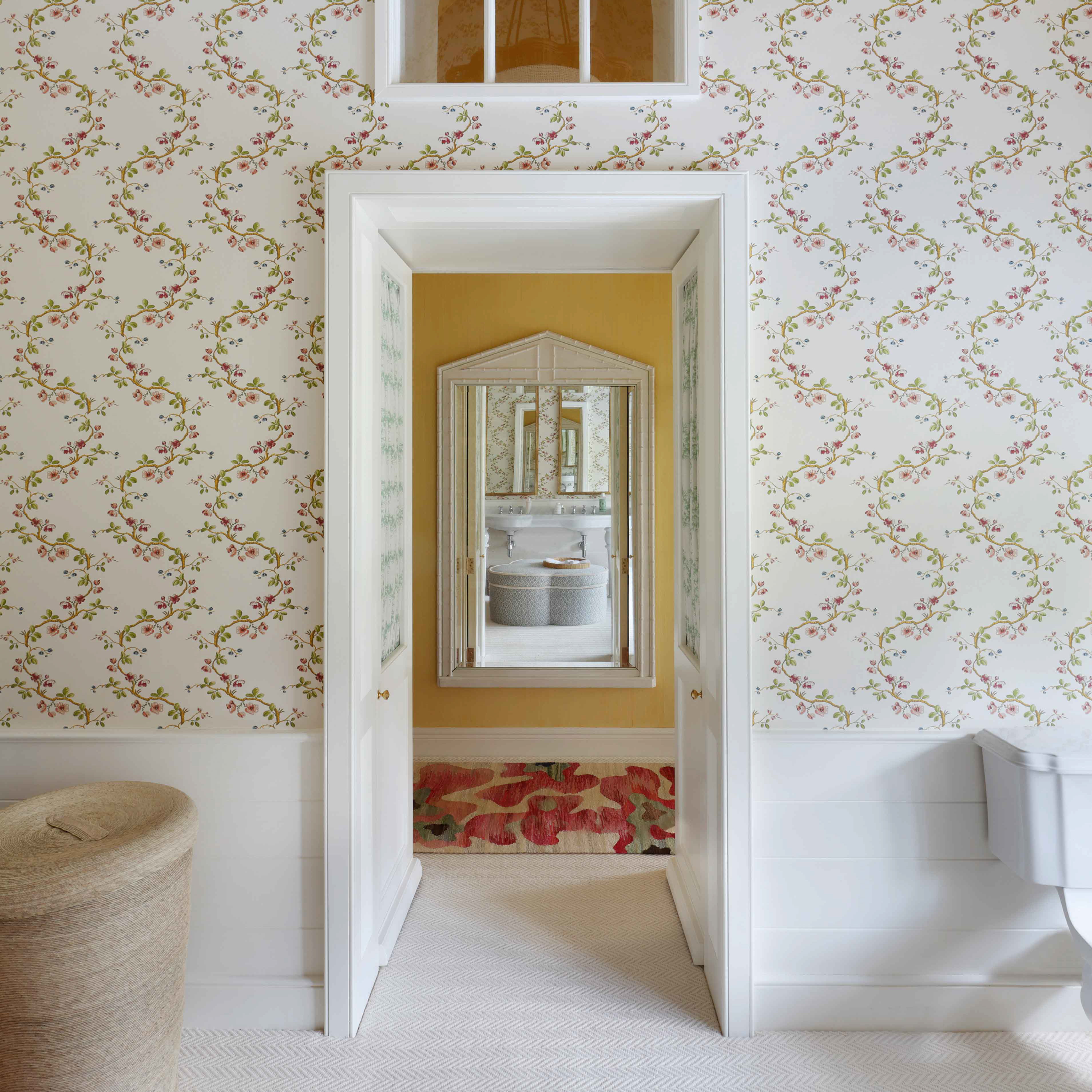 an open doorway leading to a bathroom with floral wallpaper