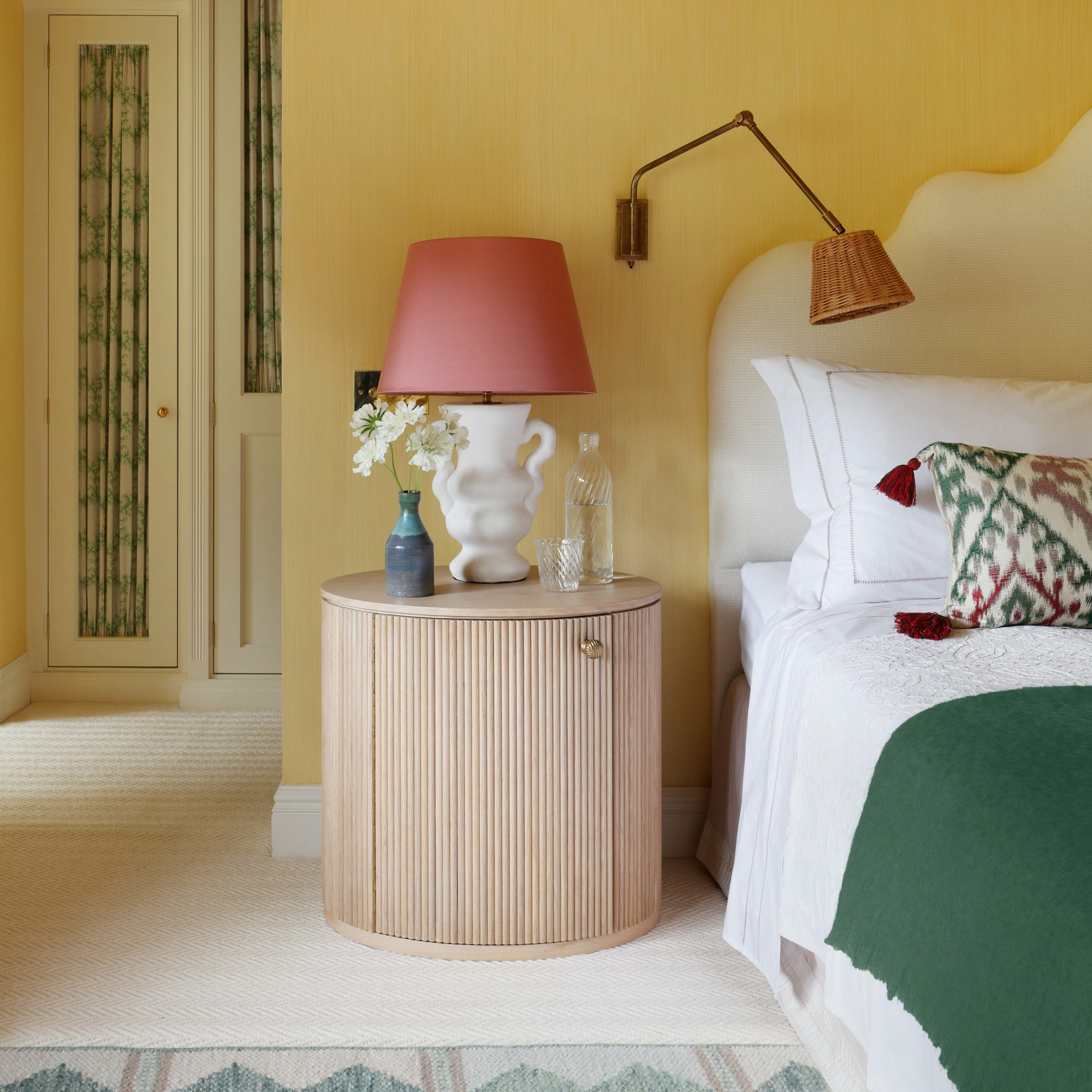 a bedroom with yellow walls and a white bed