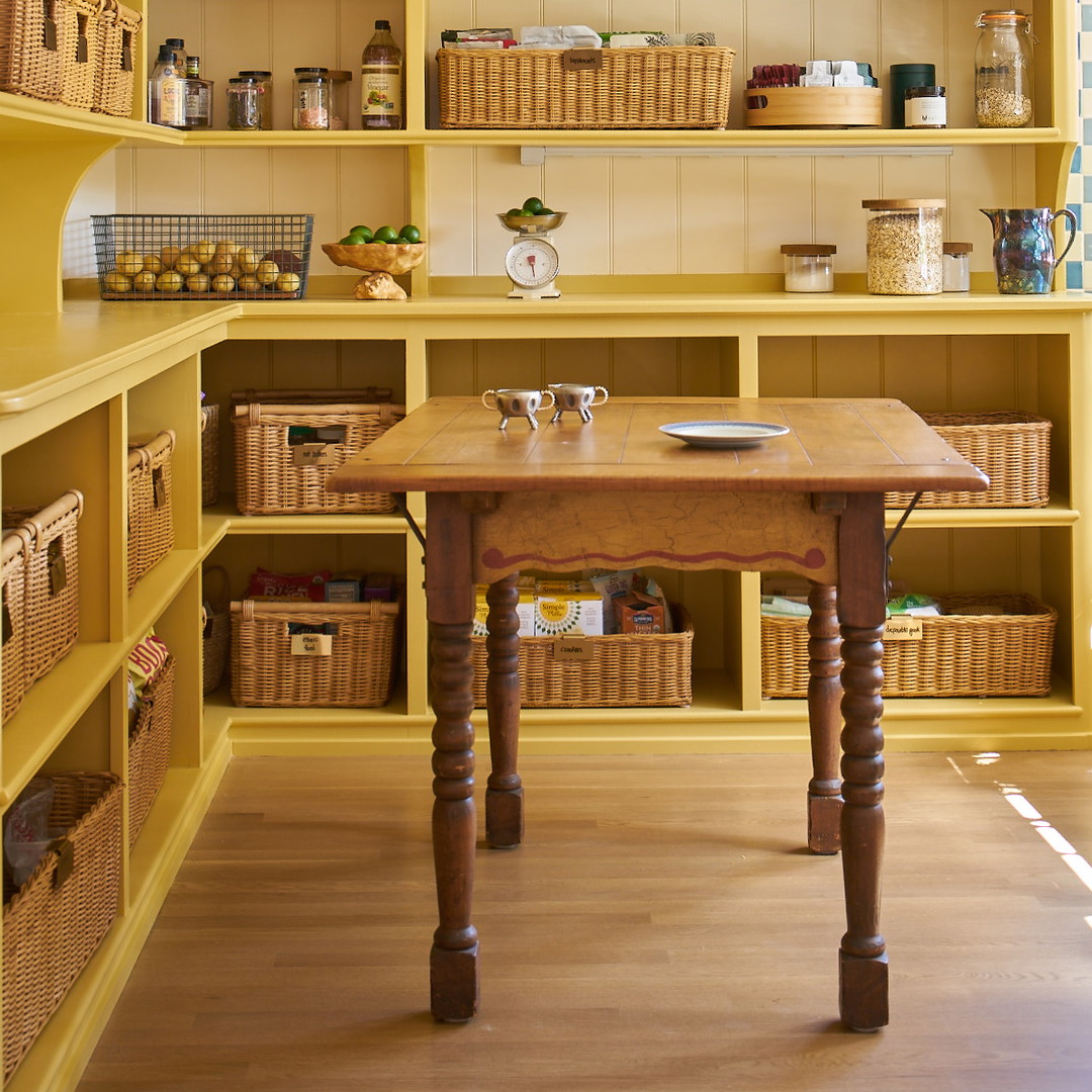 a wooden table sitting in a kitchen under a light