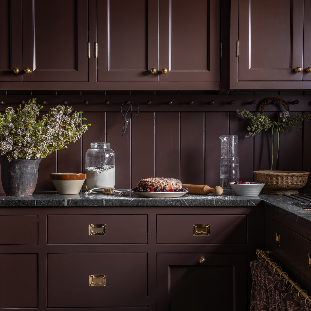 a kitchen with brown cabinets and marble counter tops