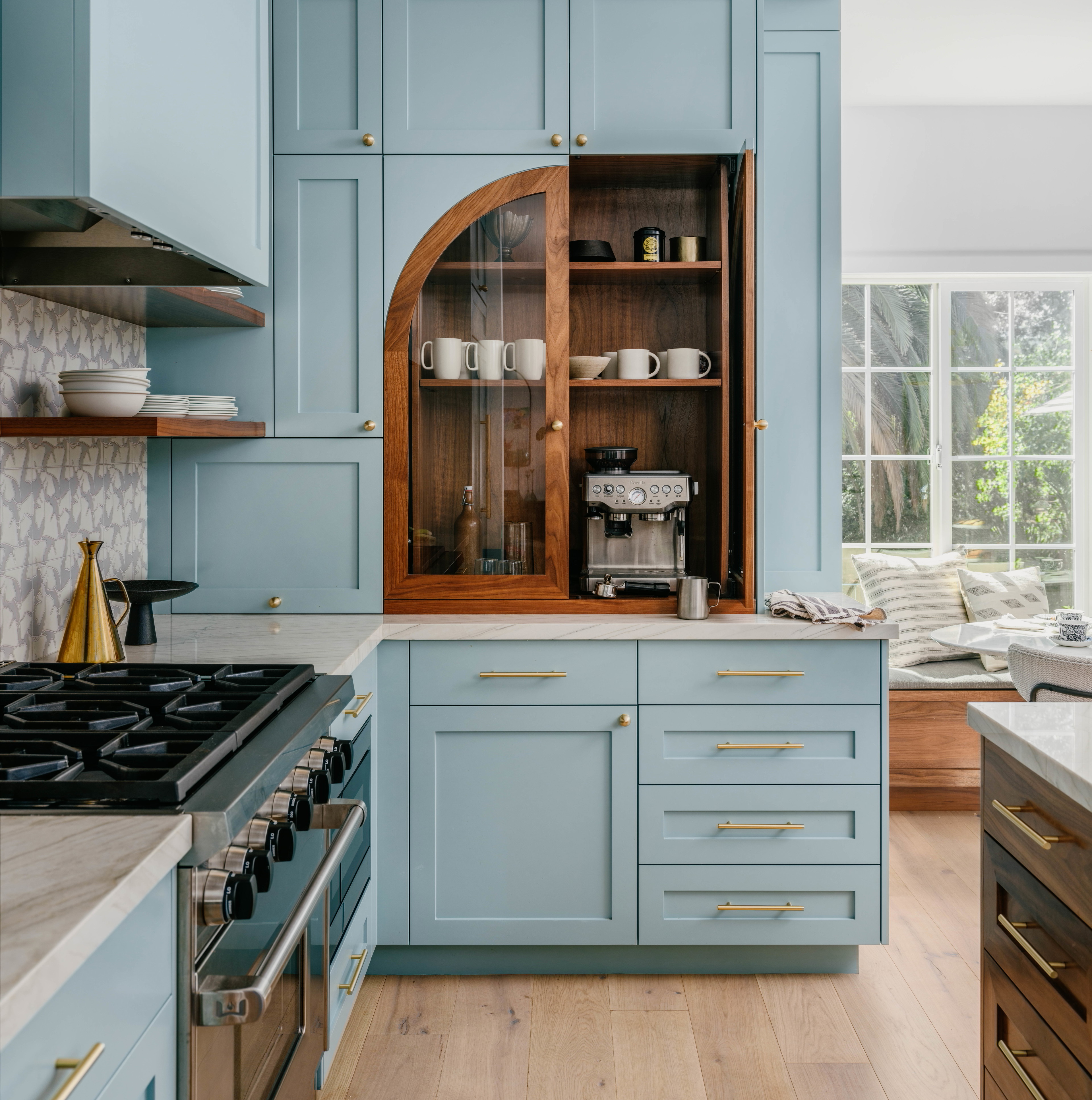 a kitchen with blue cabinets and wooden floors