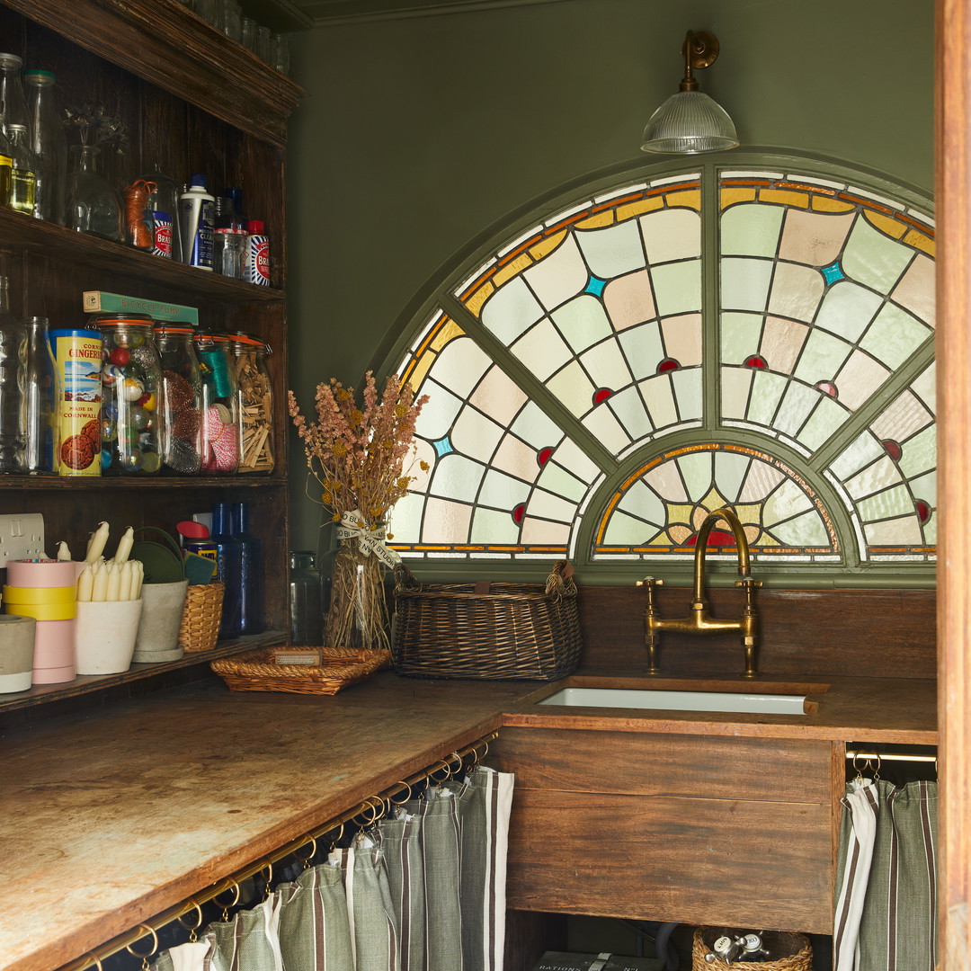 a kitchen with a stained glass window above the sink