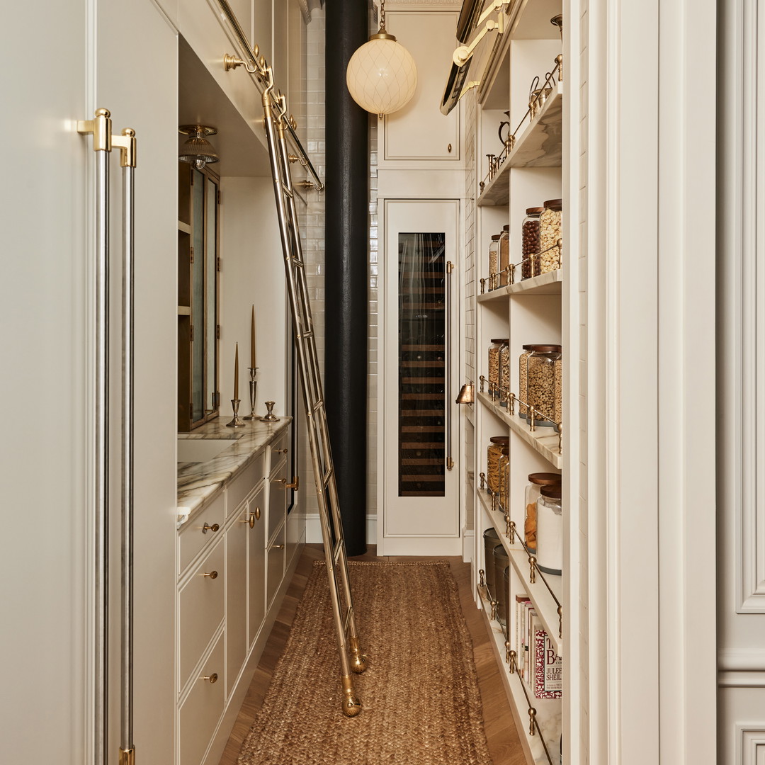 a long narrow hallway with white cabinets and shelves