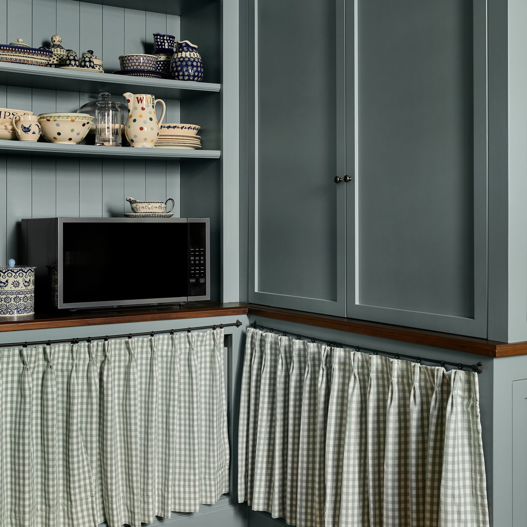 a kitchen with blue cabinets and a microwave