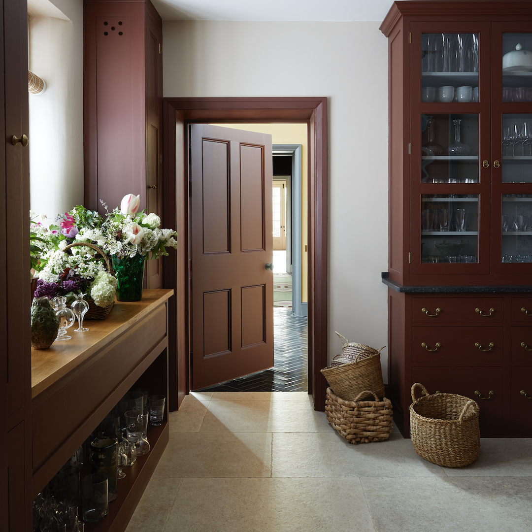 a hallway with a wooden cabinet and a vase of flowers