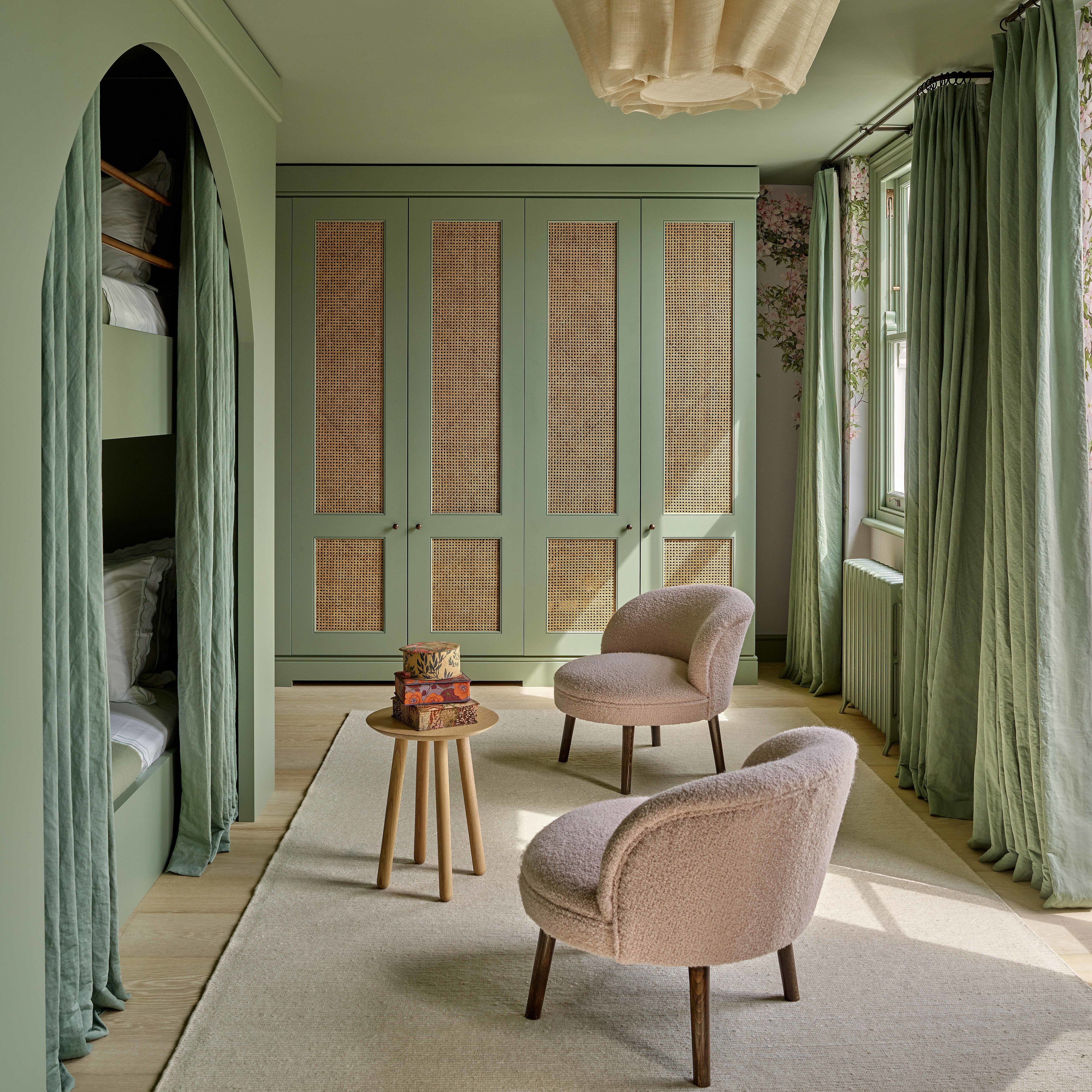 a bedroom with green walls and a chair and a table