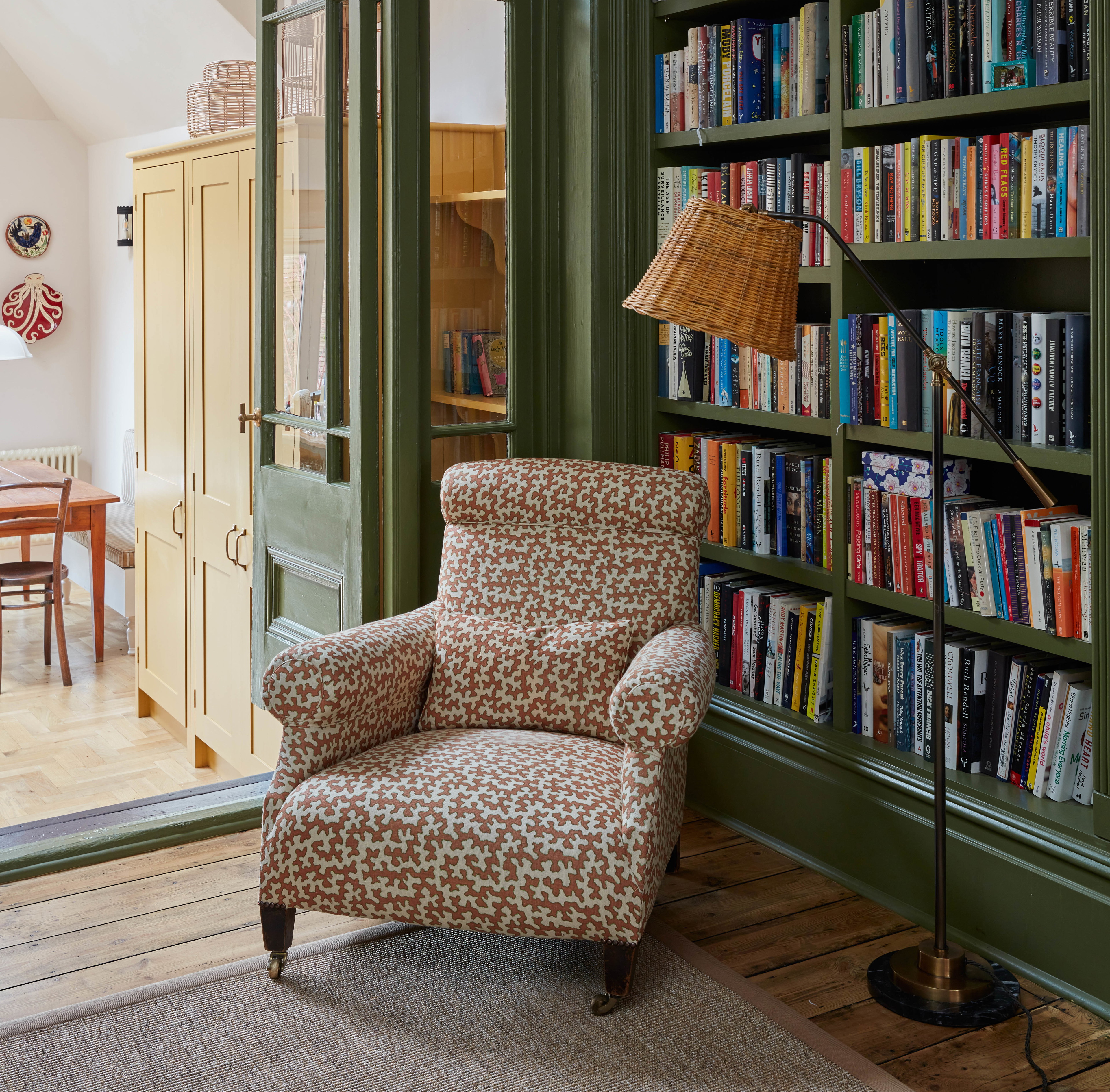 a living room with a chair and a book shelf