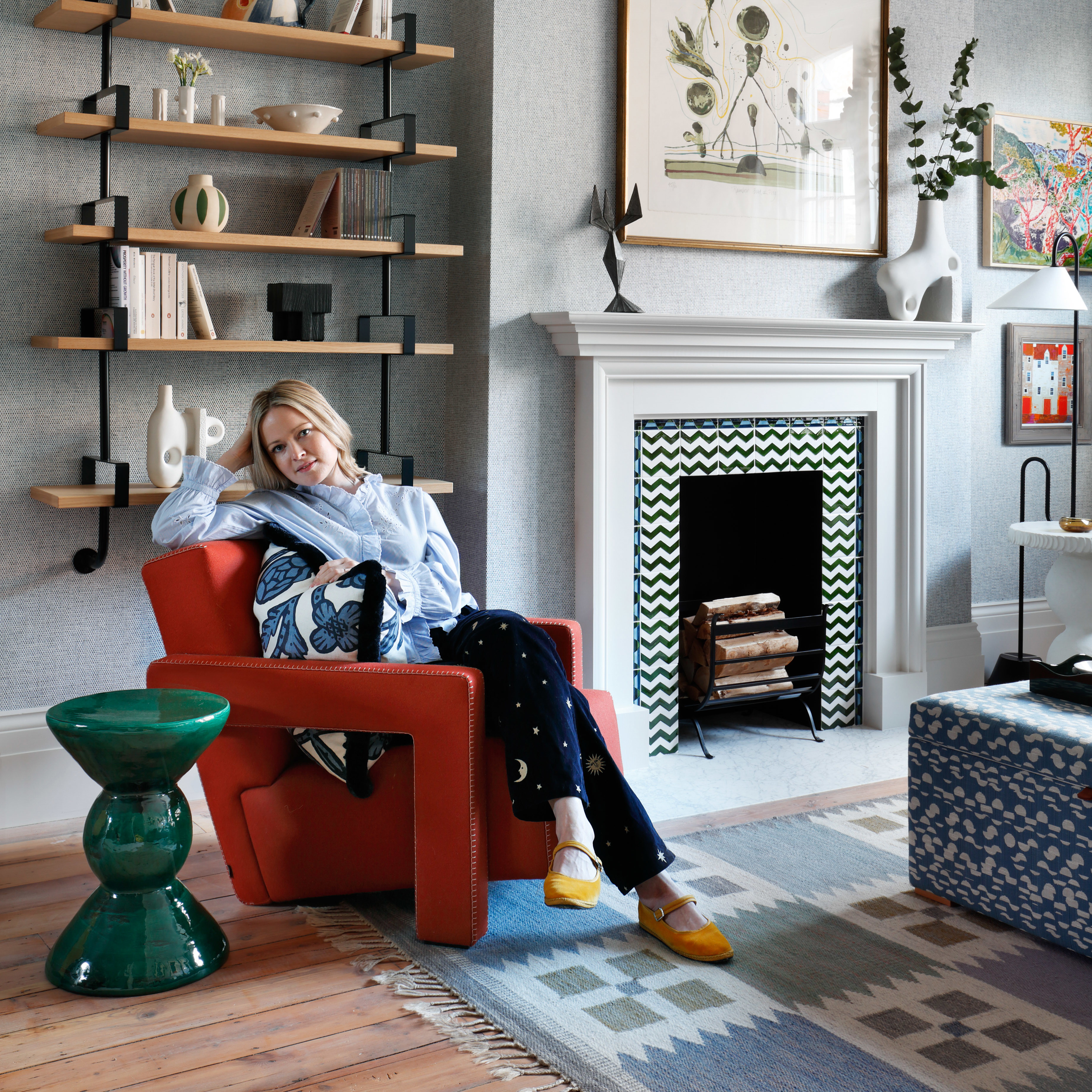 a woman sitting in a red chair in a living room