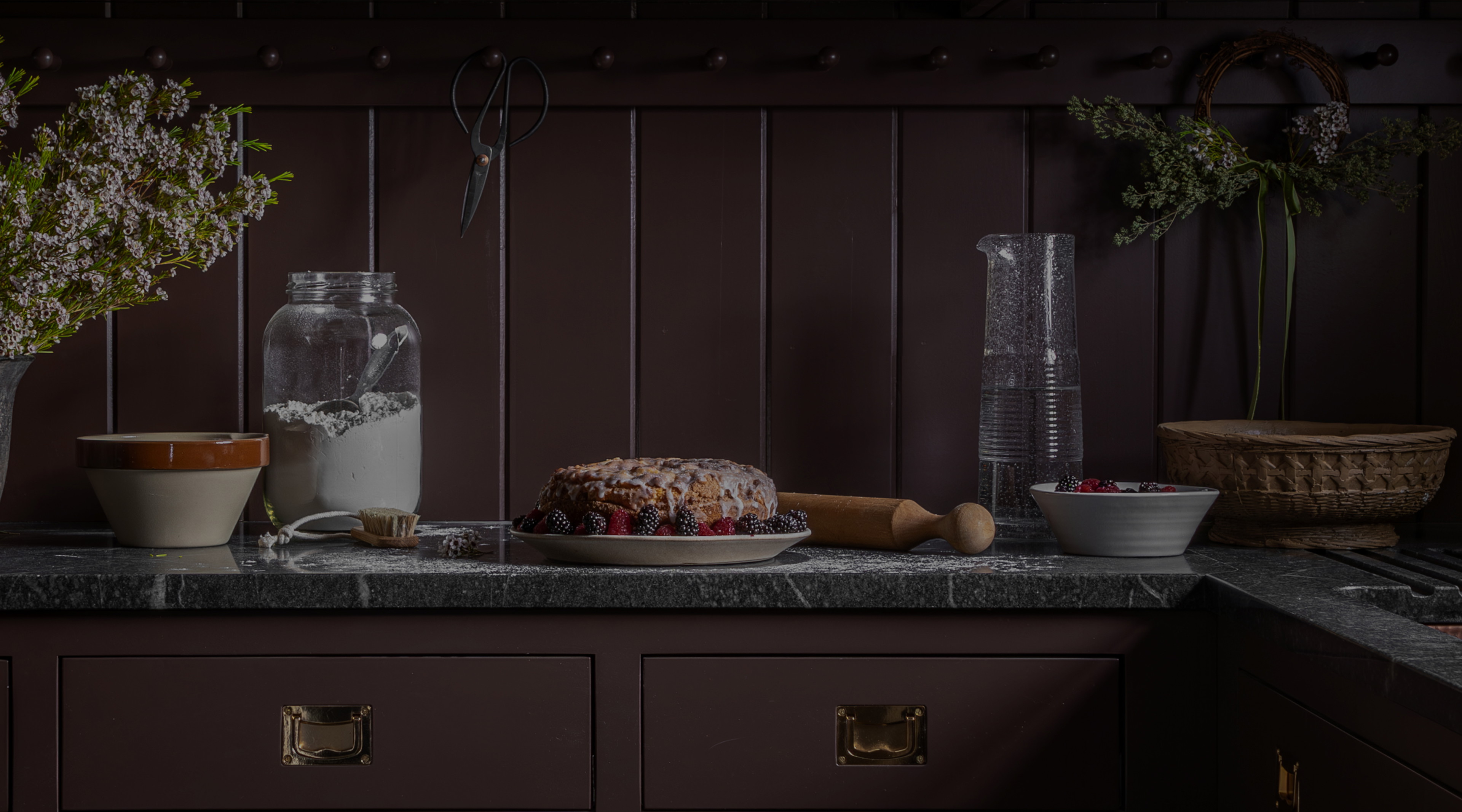 a cake sitting on top of a counter next to a vase filled with flowers